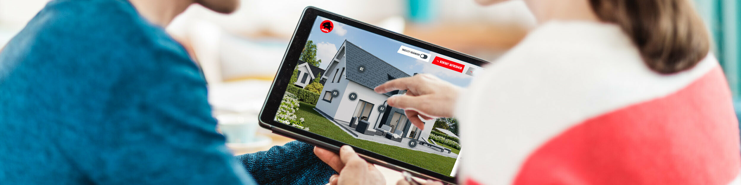 Par sjedi za stolom i na tabletu gleda digitalni prikaz kuće s aluminijskim krovom, fasadom i solarnim elementima – u kontekstu PREFA vodiča za krov, fasadu i solarne sustave za gradnju i sanaciju.
