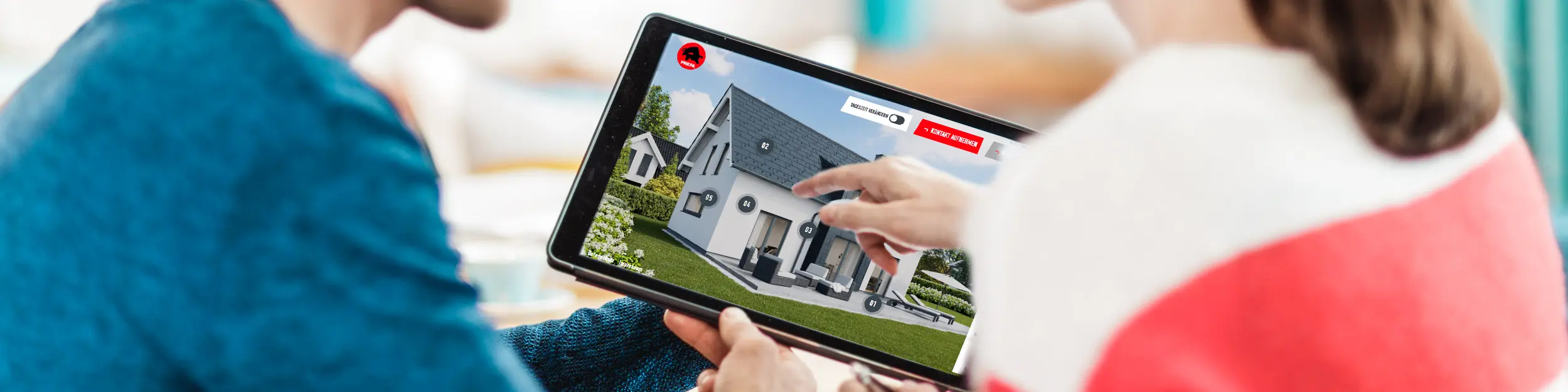 Par sjedi za stolom i na tabletu gleda digitalni prikaz kuće s aluminijskim krovom, fasadom i solarnim elementima – u kontekstu PREFA vodiča za krov, fasadu i solarne sustave za gradnju i sanaciju.
