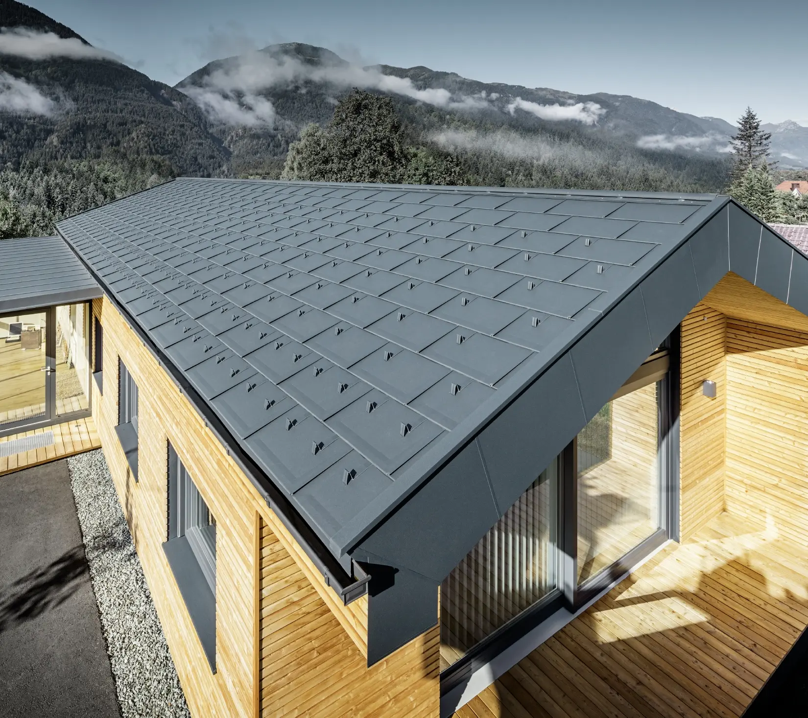 Nova uredska zgrada poduzeća Holzbau Faltheiner s fasadom od ariševine, velikim prozorskim površinama i PREFA krovom u antracit boji.