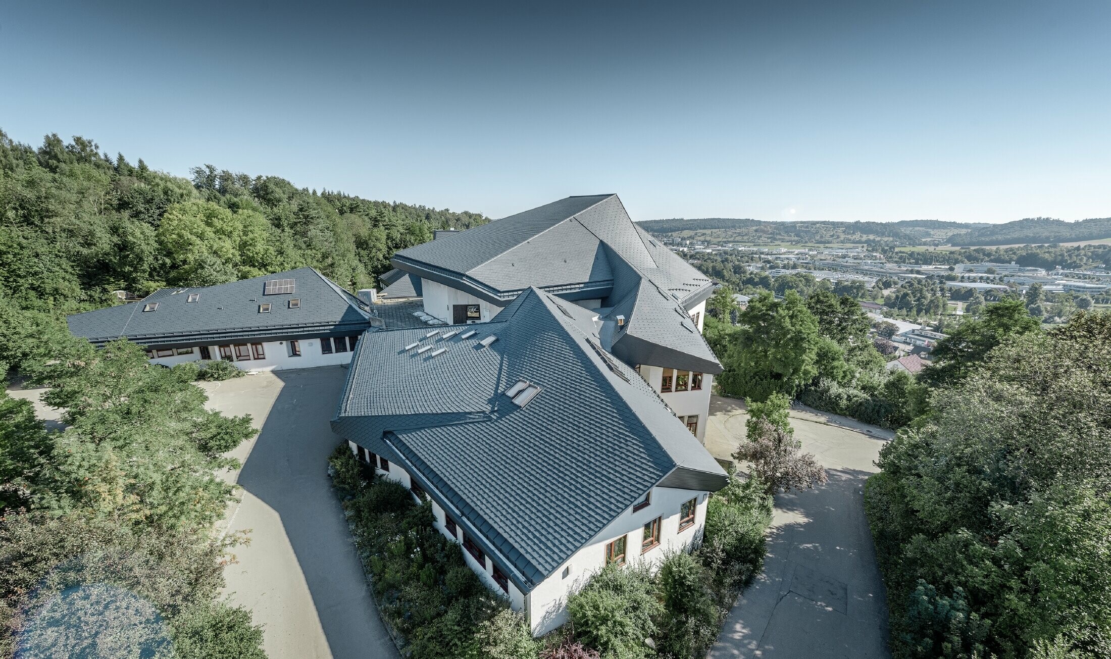 Waldorfska škola u Heidenheimu s novosaniranim krovom, velika krovna površina s mnogo kuteva i krovnih nagiba pokrivena je PREFA krovnom šindrom u antracit boji