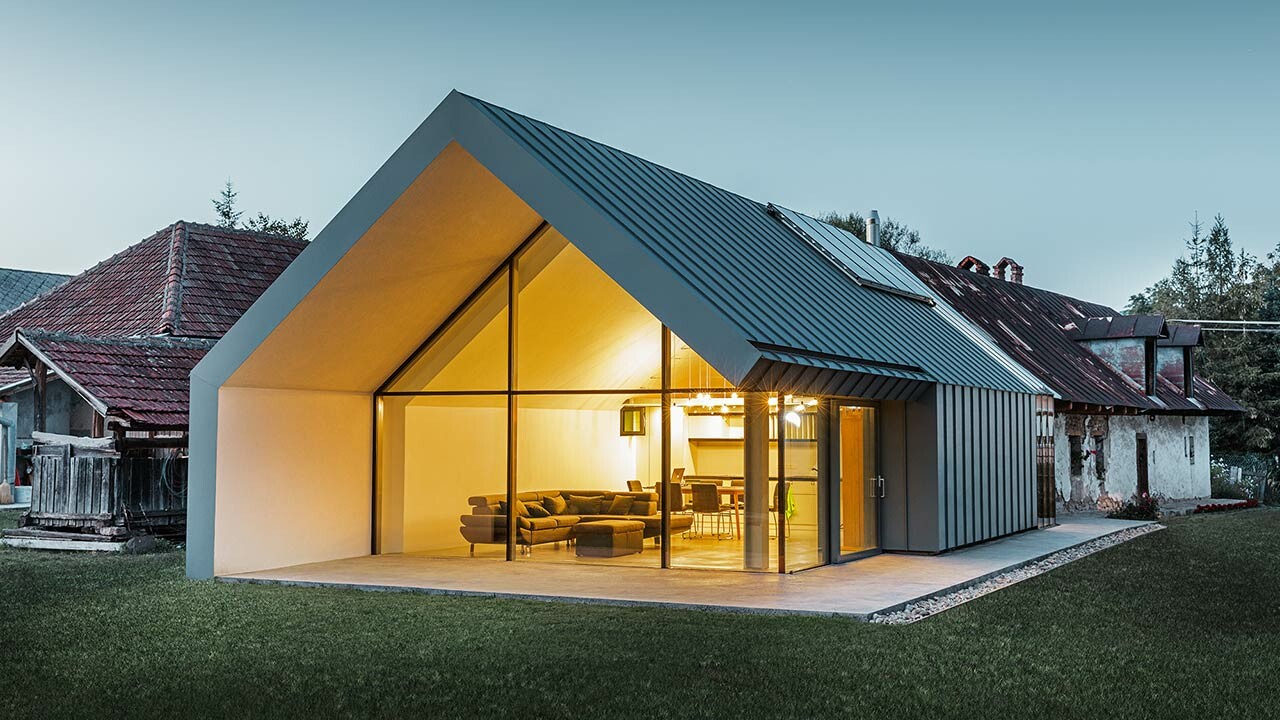 Moderna obiteljska kuća s otvorenom zabatnom stranom i krovom pokrivenim stojećim falcom tvrtke PREFA.