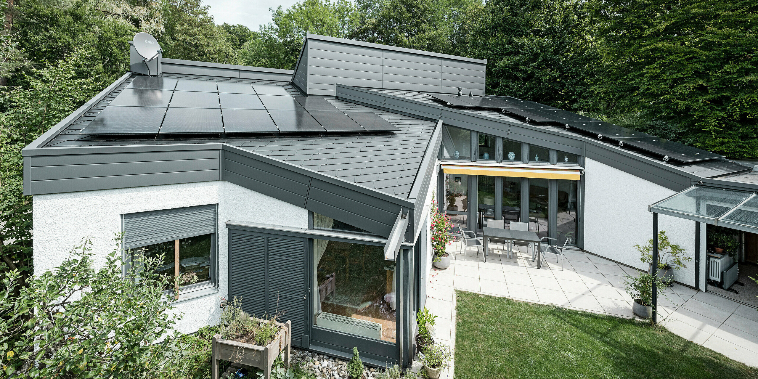 Ein Einfamilienhaus, das mit PREFA Dachschindeln DS.19 in schwarz eingedeckt wurde. Für Teile der Fassade wurden PREFA Sidings in P.10 dunkelgrau verwendet. 