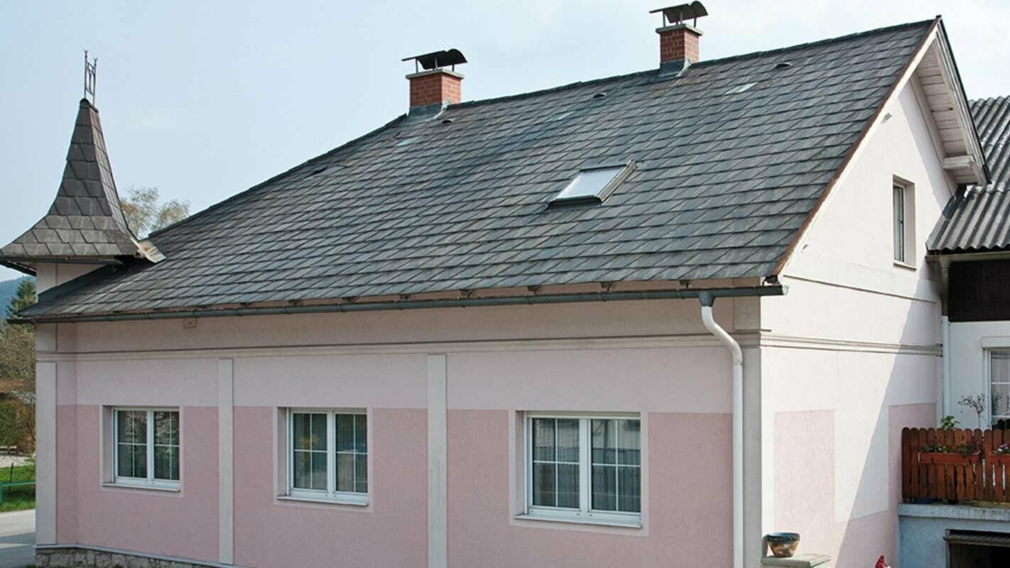 Kuća prije sanacije krova PREFA krovnom pločom u Austriji – prije toga Eternit vlaknasti cement i tornjić, roza fasada