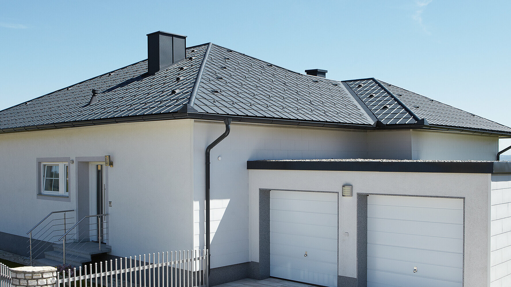 Sanirani Bungalov s četverostrešnim krovom, pokriven PREFA krovnom pločom u antracit boji. Pokraj njega se nalazi dvostruka garaža.