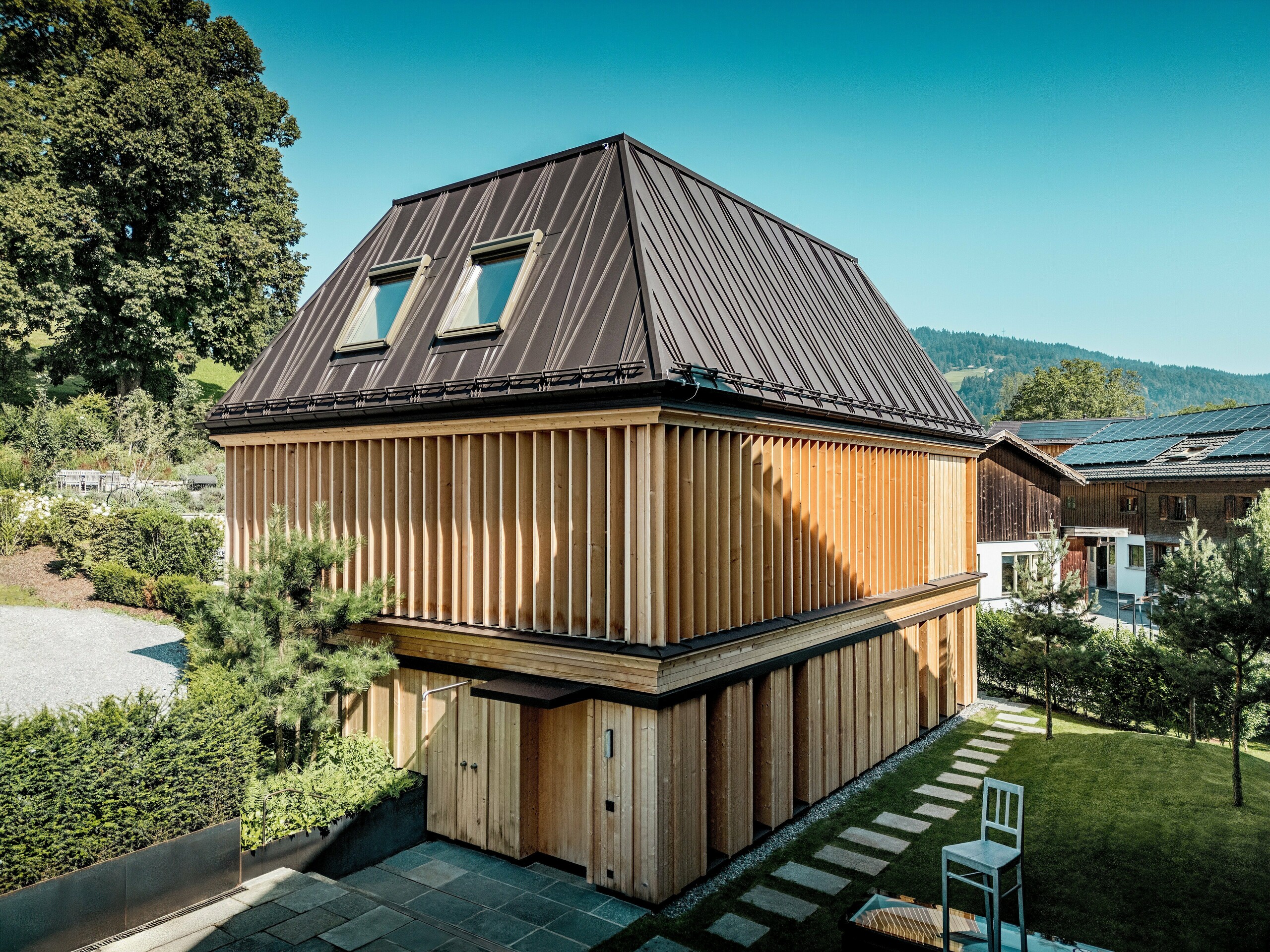 „Badehaus“ hotela Hirschen u Schwarzenbergu u bistrom, prirodnom svjetlu. U središtu pažnje ističe se izvanredan PREFA krov s falcom u boji P.10 orah smeđa, s preciznom izvedbom i upečatljivim, dijelom dijagonalno postavljenim falcima. Dva krovna prozora osiguravaju prirodno svjetlo u unutrašnjosti. Fasada je oblikovana etažom visokim, vertikalno postavljenim drvenim lamelama koje dolaze do izražaja i estetski i funkcionalno. U prvom planu prirodne kamene ploče vode kroz njegovani vrt. Okružen tradicionalnim drvenim kućama i blagim brežuljcima, moderna zgrada skladno se uklapa u izgled mjesta Bregenzerwalda.