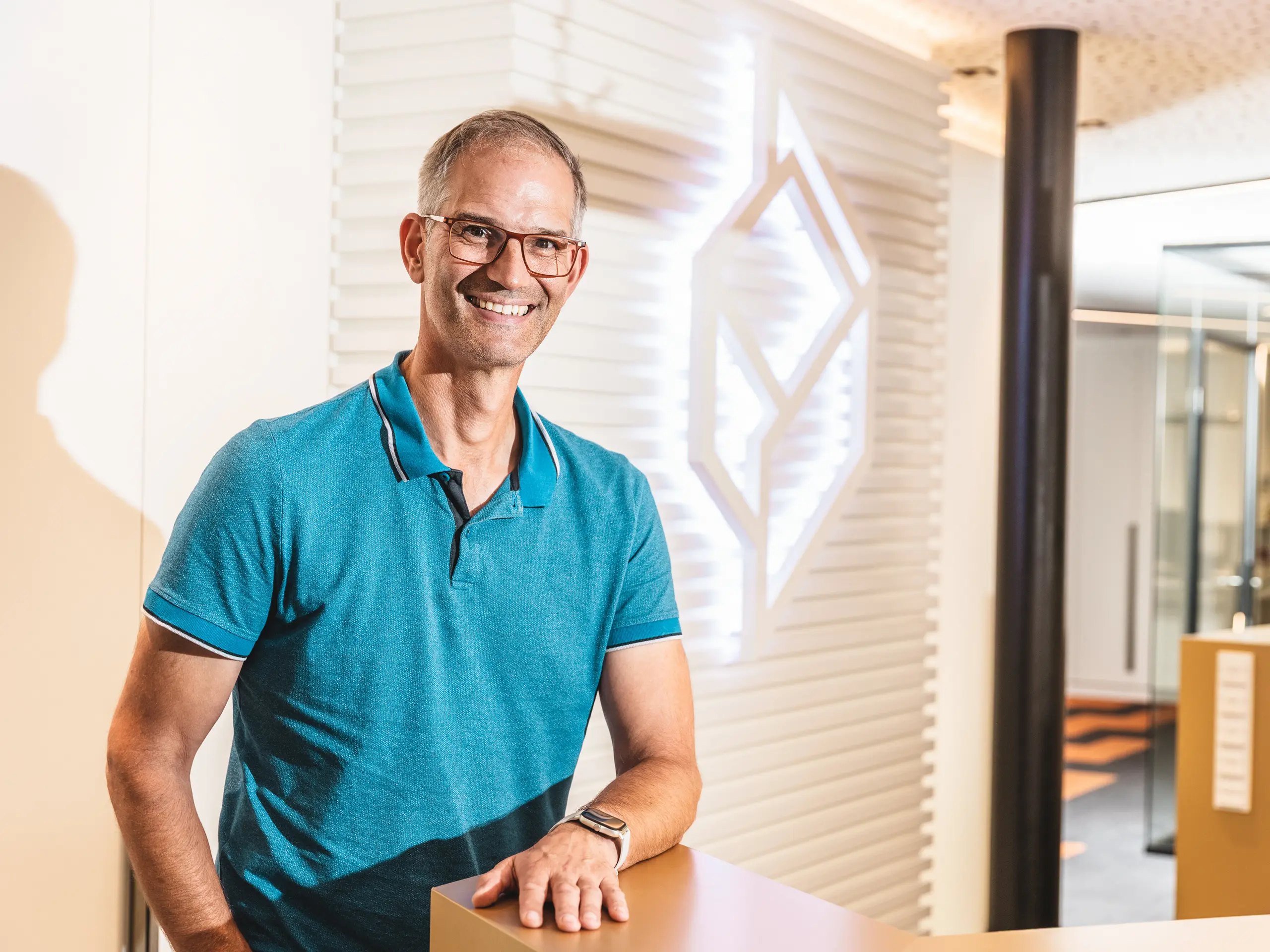 Walter Kohlmeyer iz tvrtke Kohlmeyer Fassadenbau nalazi se ispred upečatljivo strukturirane površine zida s precizno oblikovanim linijama. Kao voditelj projekta bio je odgovoran za realizaciju približno 1.100 m² fasadne površine pri proširenju Policijske postaje 43 u Hamburgu. Arhitektonski zahtjevan objekt izveden je s PREFA ekstrudiranim zupčastim profilima u brončanoj eloksiranoj završnoj obradi.