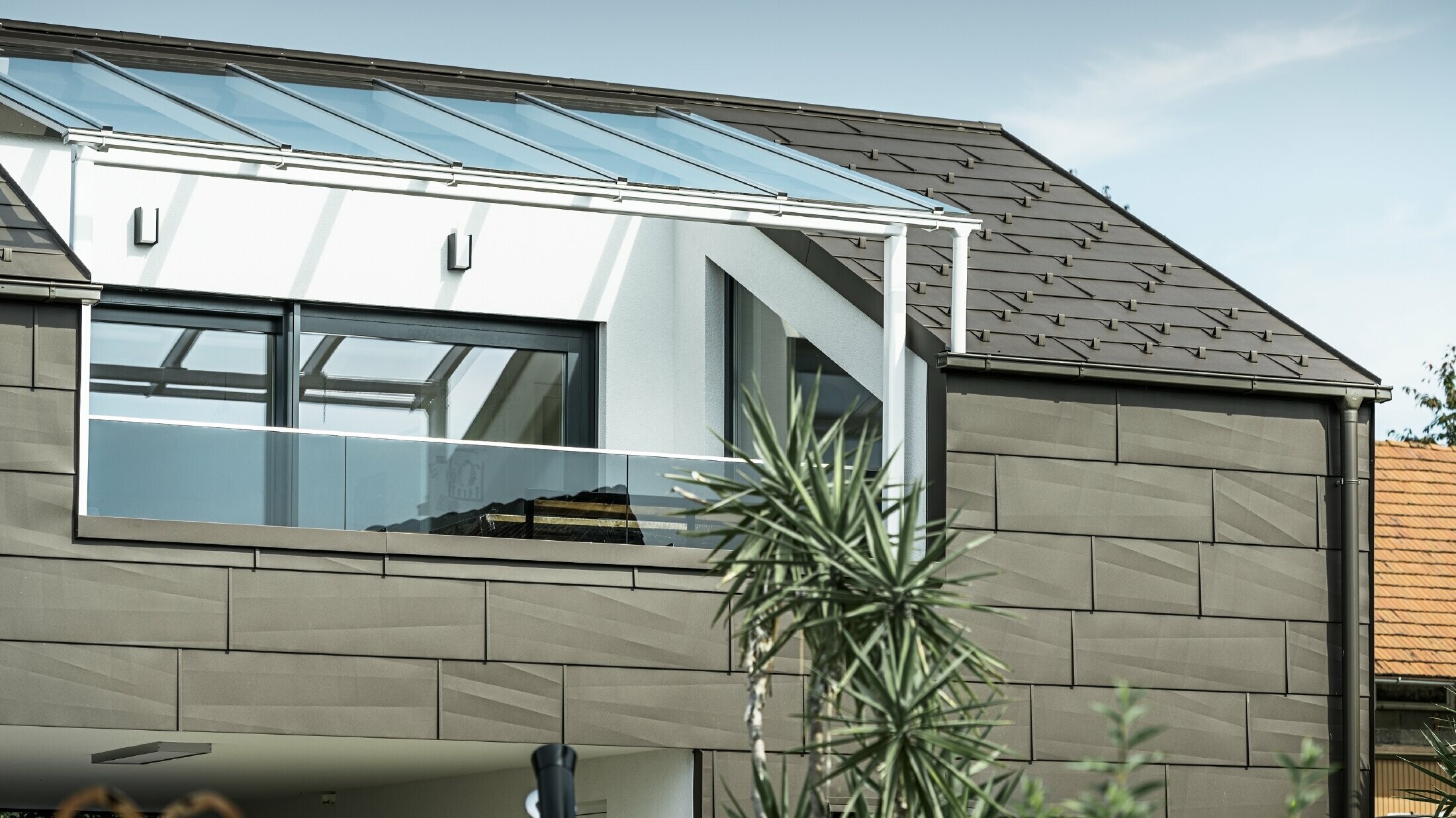Nadogradnja s krovnom terasom obložena PREFA kompletnim sustavom, na krovu i fasadi korišteni su PREFA krovni i fasadni paneli FX.12. Osim toga, za krovnu odvodnju koriste se PREFA sandučasti žlijeb s PREFA odvodnom cijevi i opsežni pribor u smeđoj boji.