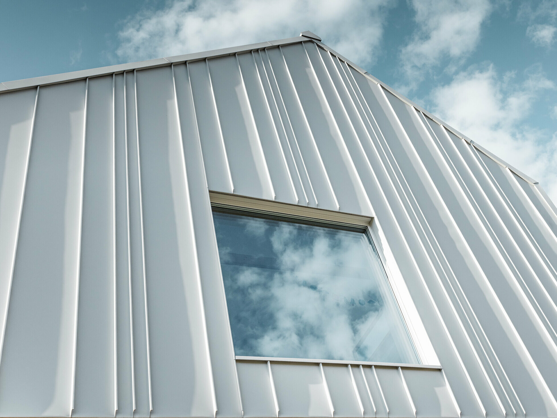 bijeli sustav PREFALZ kao kutni stojeći falc na fasadi s različitim širinama paleta i jednim prozorom