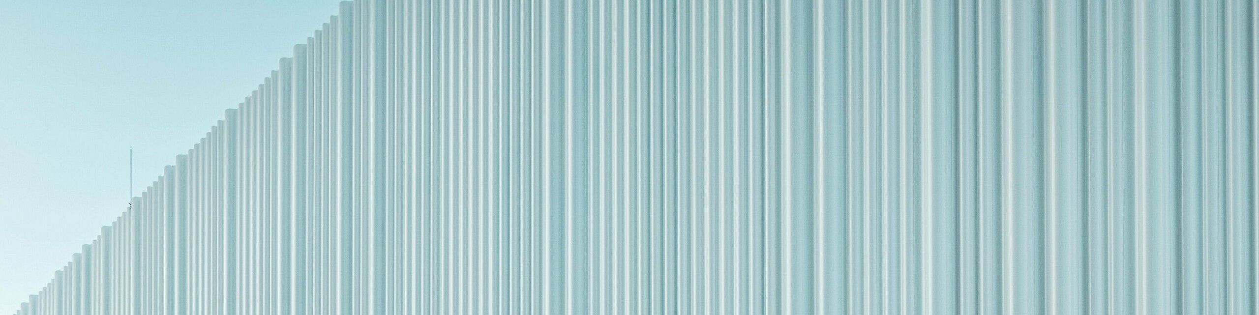 Spektakularno oblikovanje fasade s PREFA valovitim ekstruzijskim profilom od visokokvalitetnog aluminija krasi poslovnu zgradu LKW Walter u Beču. Nježno zakrivljena, vertikalno postavljena struktura profila stvara elegantan valoviti uzorak koji proizvodi fascinantnu igru svjetla i sjene. Dok moderno zdanje oduševljava jasnom formom, zakrivljeni dio fasade stvara upečatljiv arhitektonski kontrast. Dugotrajni i otporni na koroziju aluminijski profili s nevidljivim pričvršćivanjem osiguravaju visokokvalitetnu i bez održavanja vanjsku površinu.