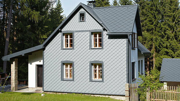 Obiteljska kuća s PREFA kompletnim sustavom; Fasada je pokrivena PREFA zidnim rombom 29 u svijetlo sivoj.