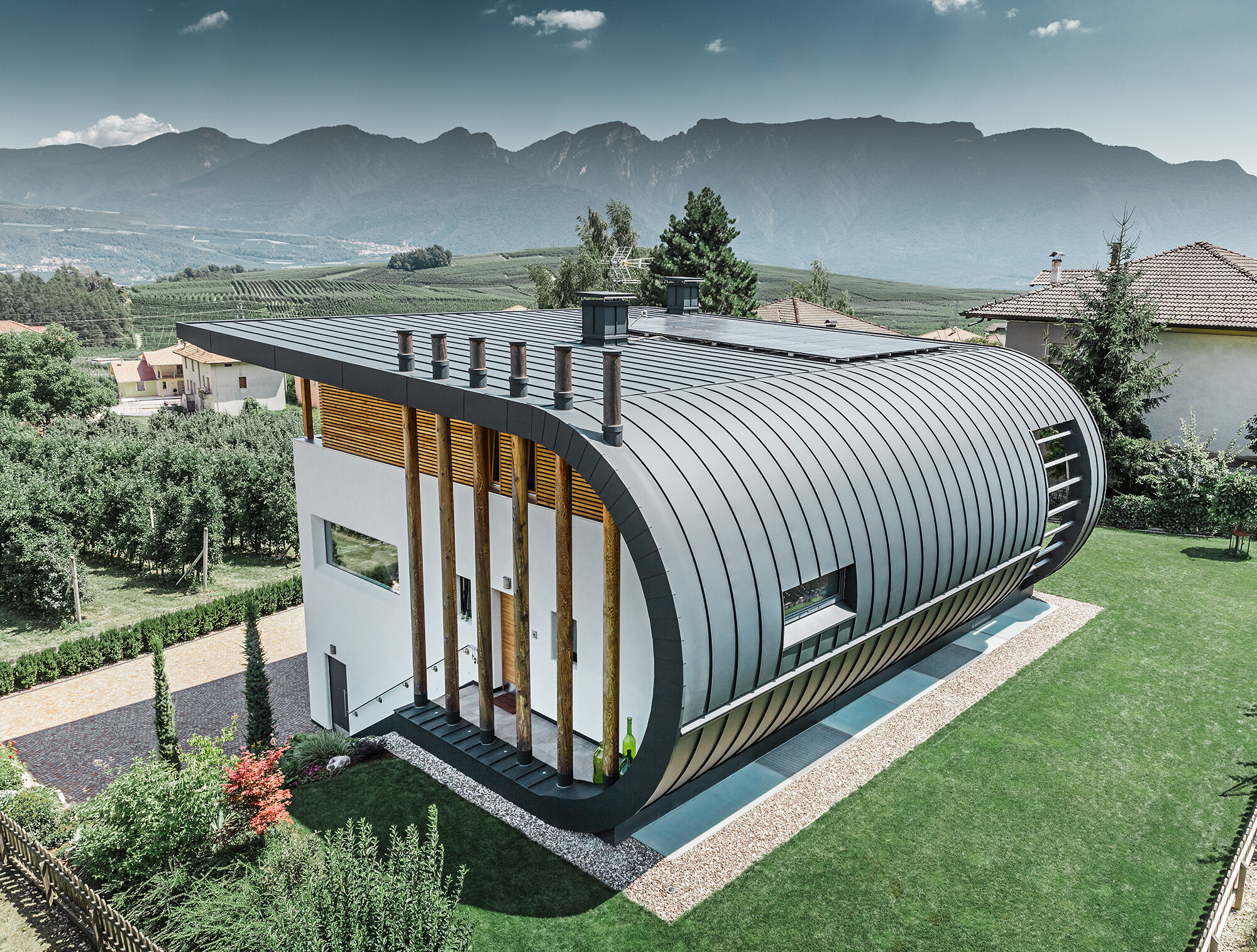 Samostojeća kuća u Italiji sa zaobljenim krovnom i fasadnom oblogom od PREFALZ-a u P.10 antracitnoj boji