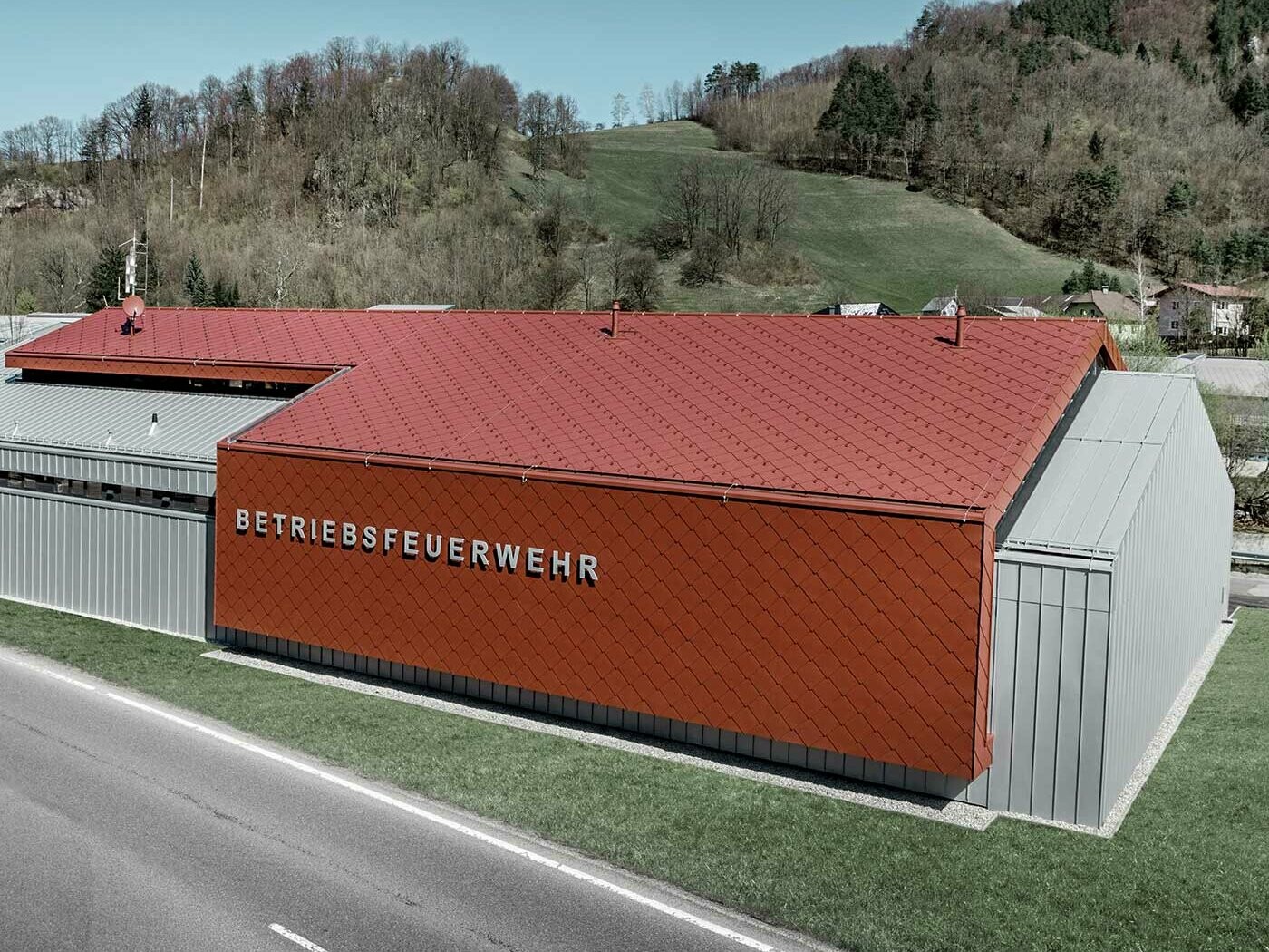 Nova zgrada vatrogasne službe tvrtki PREFA i Neuman Aluminium obložena je novim krovnim i zidnim rombom 44 x 44 u P.10 oksid crvenoj te Prefalz-om u srebrnoj metalik boji.