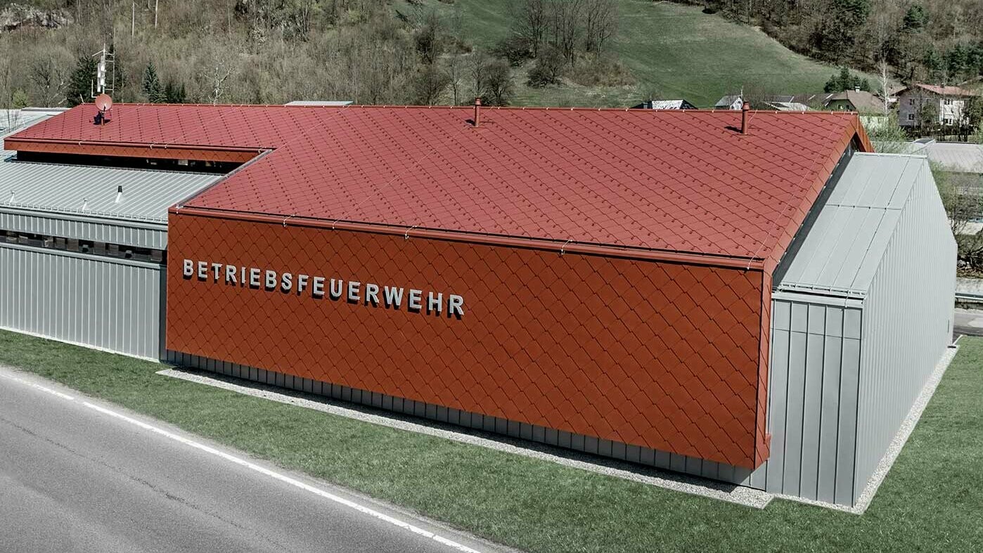 Nova zgrada vatrogasne službe tvrtki PREFA i Neuman Aluminium obložena je novim krovnim i zidnim rombom 44 x 44 u P.10 oksid crvenoj te Prefalz-om u srebrnoj metalik boji.