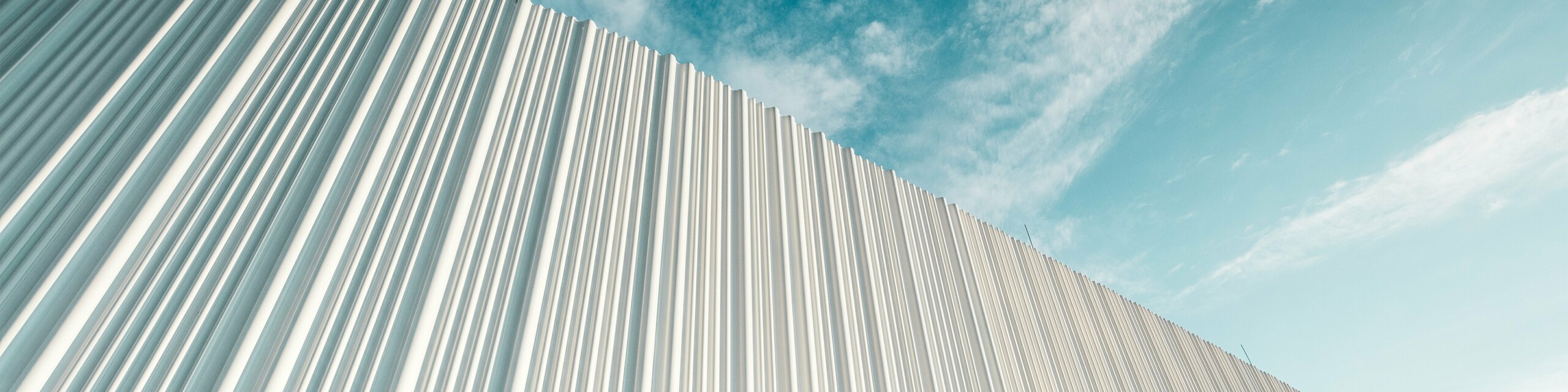 Zapanjujuća arhitektura s bijelom PREFA aluminijskom fasadom u poslovnom parku Walter u blizini Beča. Fasada od individualno izrađenih profila, zahvaljujući svom tečnom valovitom karakteru, stvara fascinantnu igru svjetla i sjene. Tri različita oblika profila osiguravaju izniman osjećaj dubine te zgradi daju stilski čistu, a istodobno dinamičnu vizualnu pojavnost. Dugotrajna, na vremenske utjecaje otporna PREFA površina spaja modernu estetiku s funkcionalnim savršenstvom – pravi vrhunac suvremenog oblikovanja fasada koji jasno ističe arhitektonsku kvalitetu i tehničku sofisticiranost.