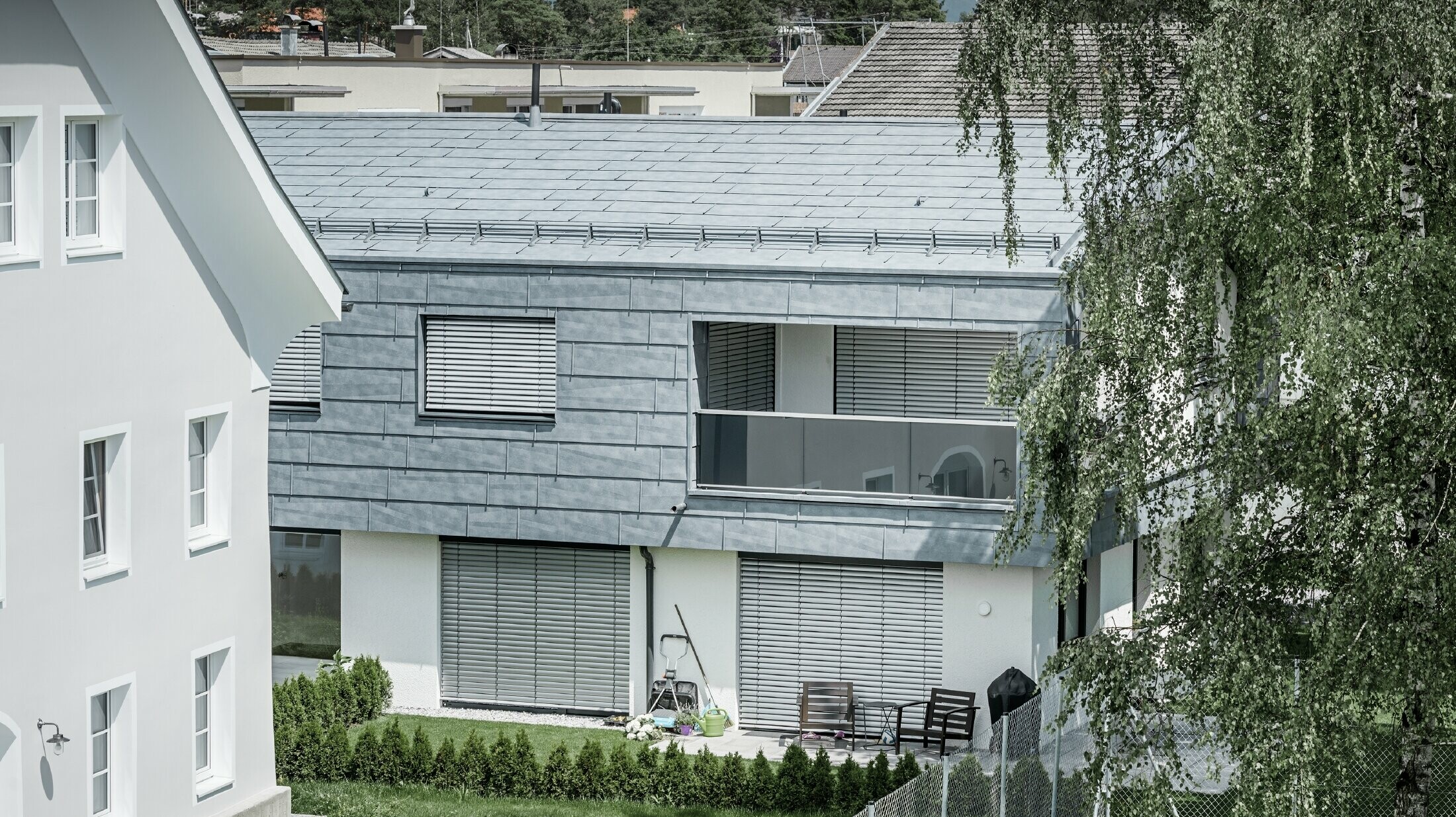 Klasična obiteljska kuća s dvostrešnim krovom i dvije krovne kućice, pokrivena PREFA krovnim panelom FX.12 u kameno sivoj.