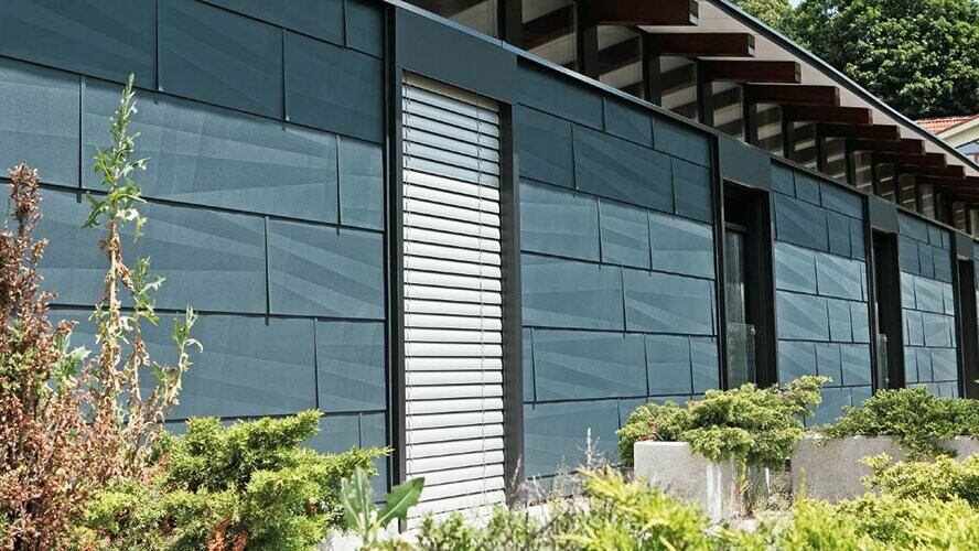 Moderno oblikovana strana izložena vremenskim utjecajima s fasadnim panelom FX.12 u antracit boji i vrtom.