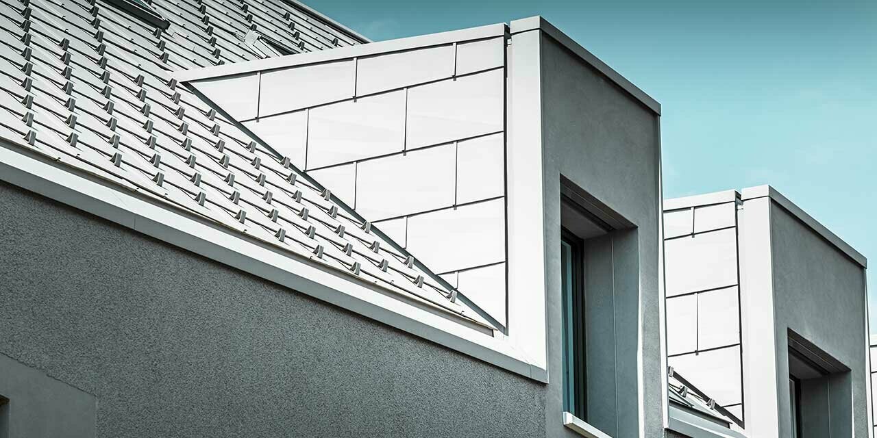 Krovne kućice na višestambenoj zgradi u Aeschu, obložene PREFA panelom FX.12 u bijeloj boji.