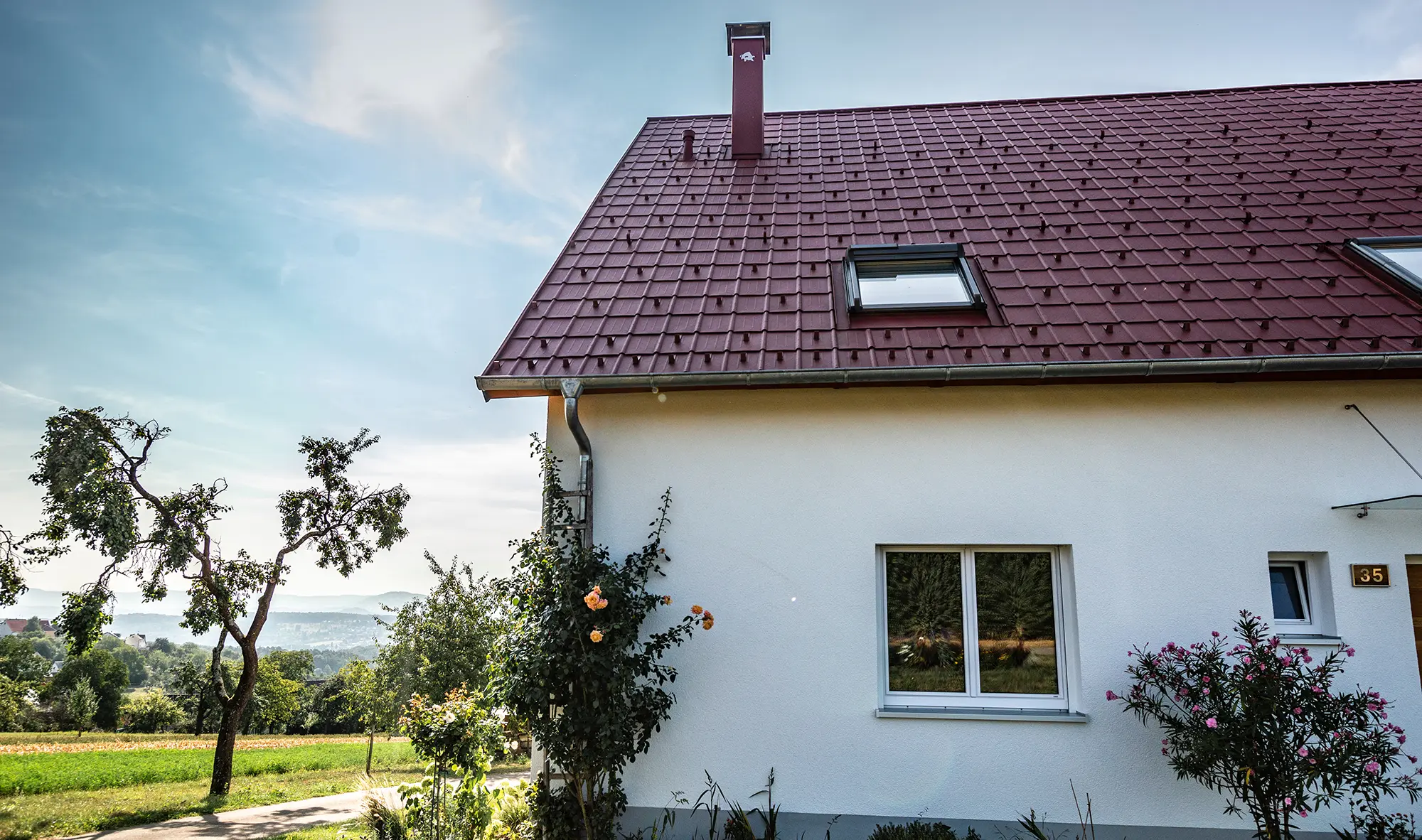 Kućica na selu, novo sanirani krov s PREFA krovnom pločom u oksid crvenoj, krovni prozor i opšav dimnjaka.
