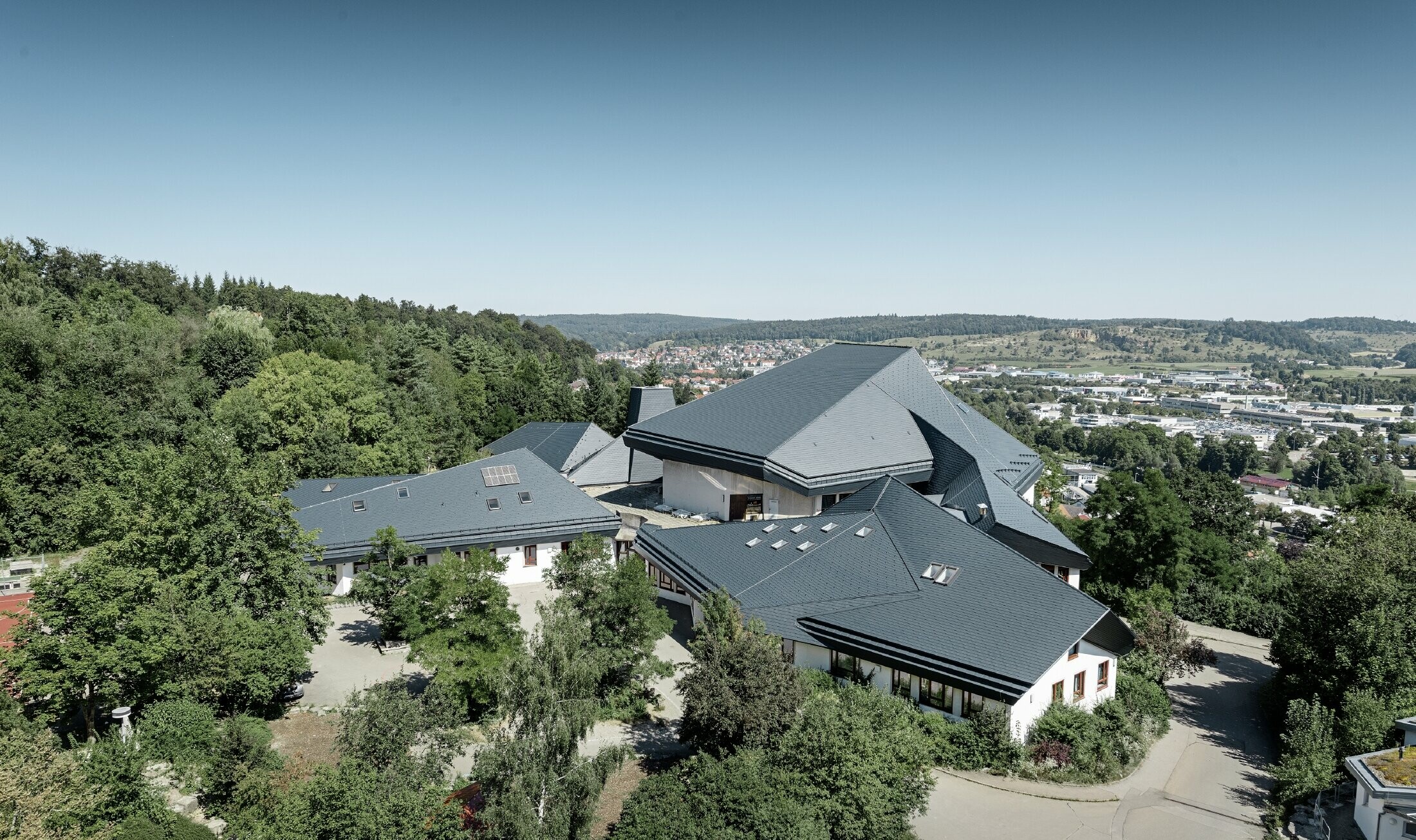 Waldorfska škola u Heidenheimu s novosaniranim krovom, velika krovna površina s mnogo kuteva i krovnih nagiba pokrivena je PREFA krovnom šindrom u antracit boji