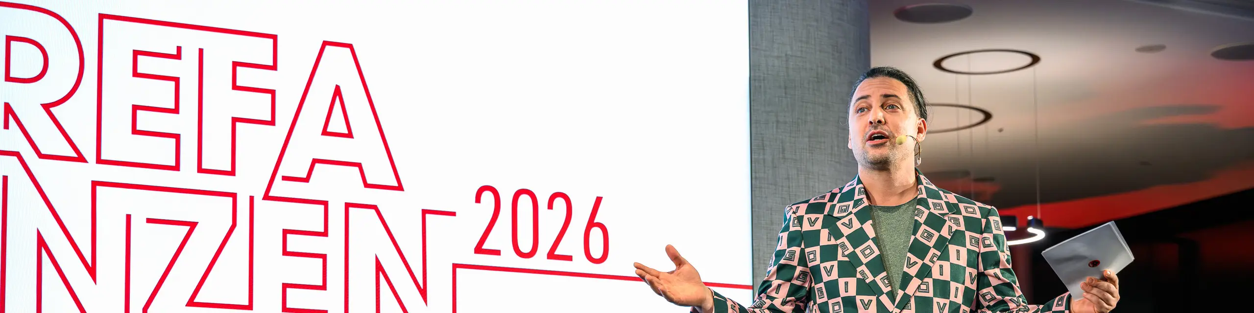 Trenutak na pozornici s wow-efektom na PREFARENZEN prezentaciji 2026.: Moderator Serkan Temel oduševio je publiku svojim šarmom, humorom i upečatljivim outfitom. Njegova prisutnost naglašava kreativan duh događanja, koji spaja inovaciju, dizajn i zajedništvo. Večer za pamćenje u K47.wien, koja pokazuje kako se danas s PREFA aluminijem zamišlja i živi moderna i svestrana arhitektura.