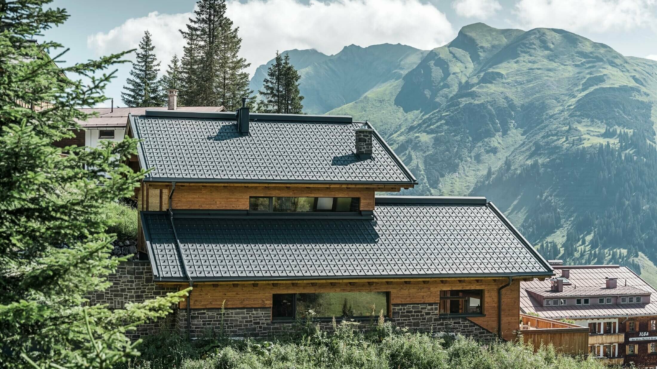 Kuća na Alpama s PREFA krovnim pločama u antracit boji, kao krovnim pokrovom.