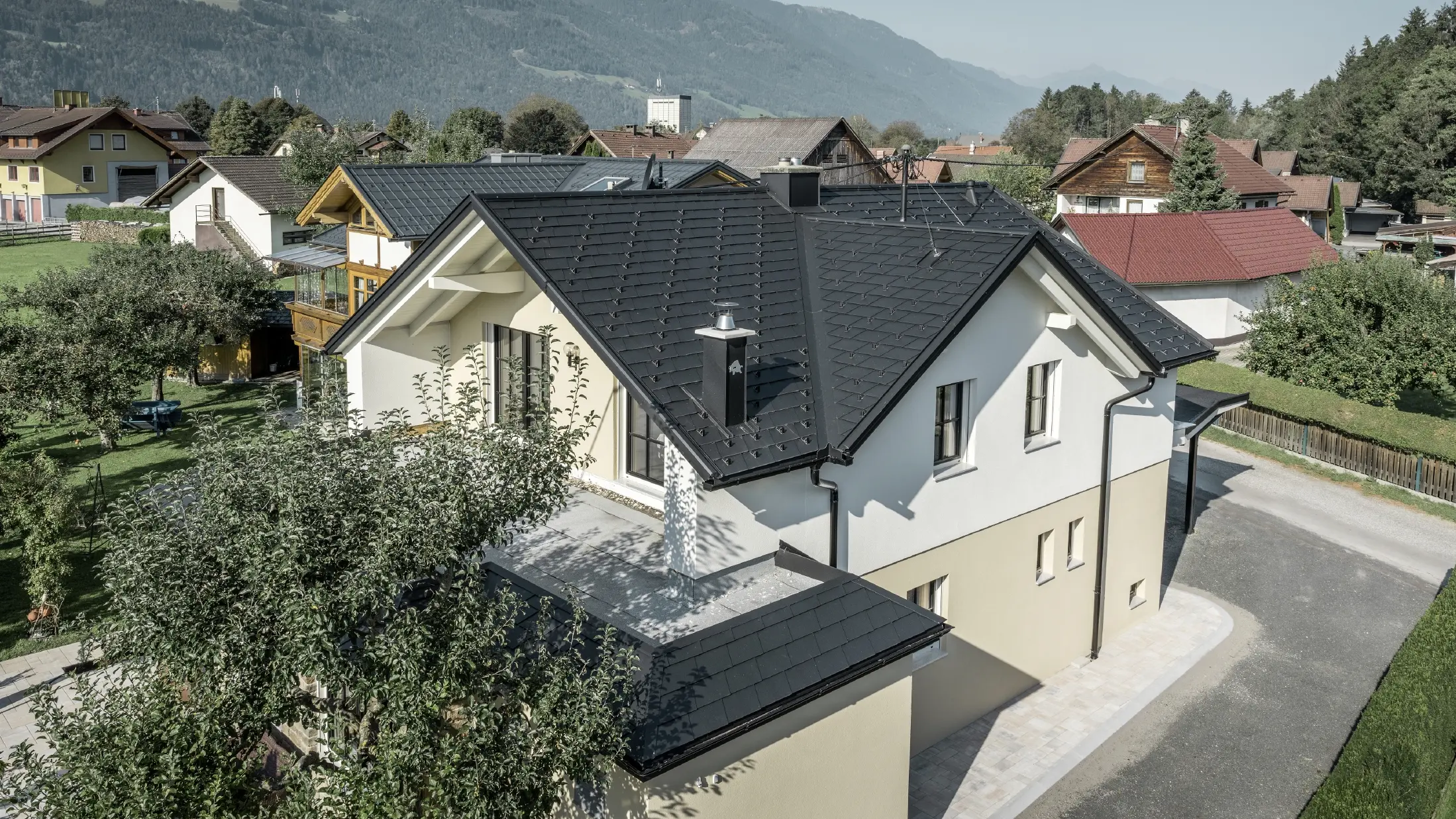 Tradicionalna obiteljska kuća s dvovodnim krovom i velikim mansardnim prozorom, nedavno renovirana. Krov je pokriven crnom PREFA šindrom.