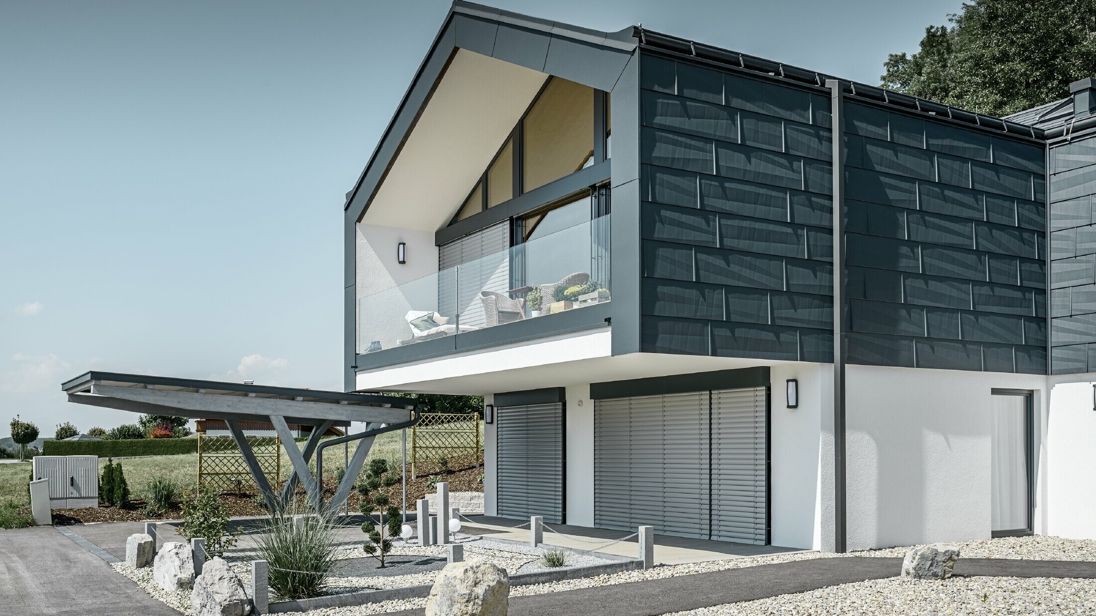 Moderna višeobiteljska kuća s velikim prozorskim pročeljem, krovom i fasadom obložena je PREFA krovnim i fasadnim panelom FX.12 u antracit boji