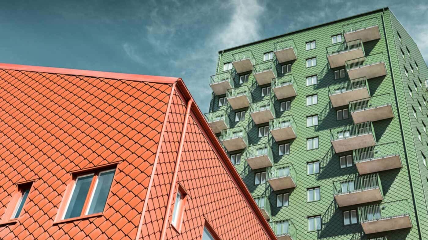 Švedske stambene zgrade s balkonima i PREFA zidnim rombom u zelenoj i ciglasto crvenoj.
