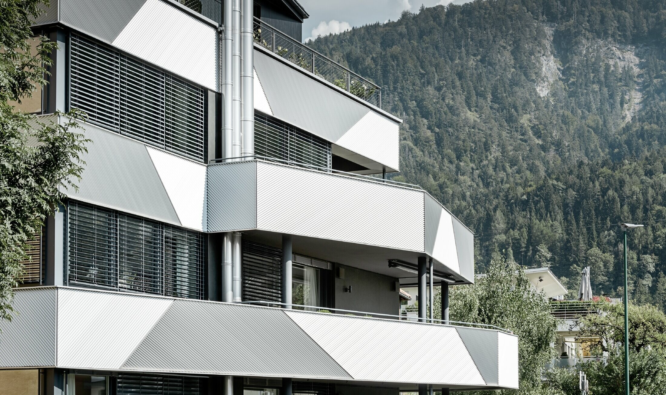 Oblikovanje fasade za višestambenu zgradu s balkonima i lođama PREFA zupčastim profilom s kosim polaganjem.