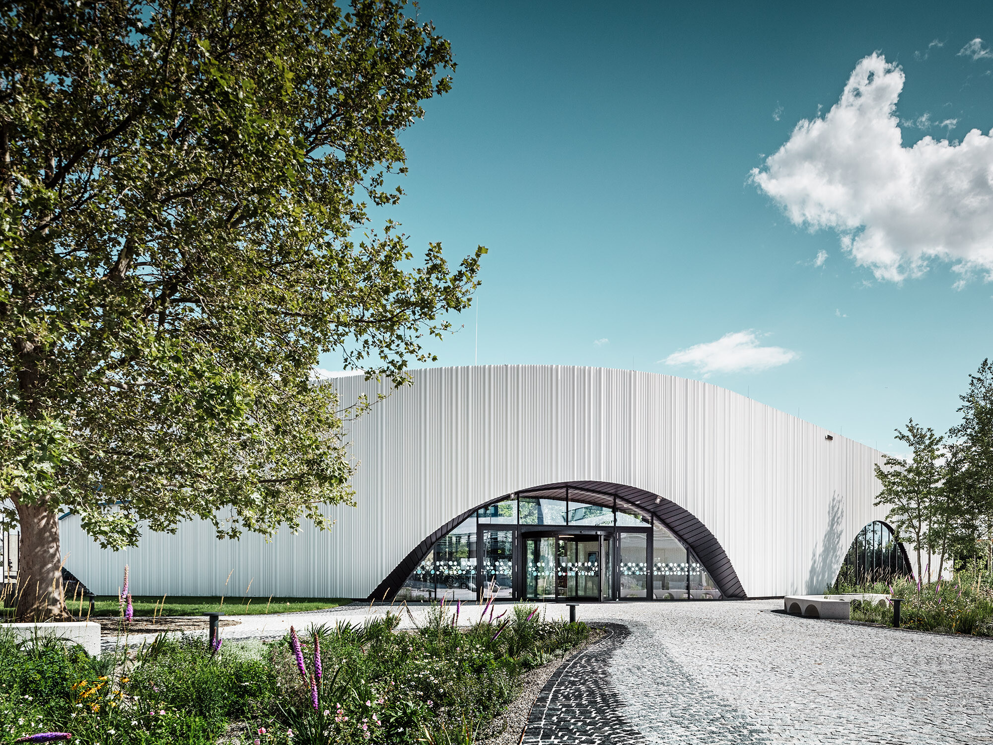 Normalan pogled na restoran Walters s jednim od svojih lučnih prozora, okružen zelenilom.