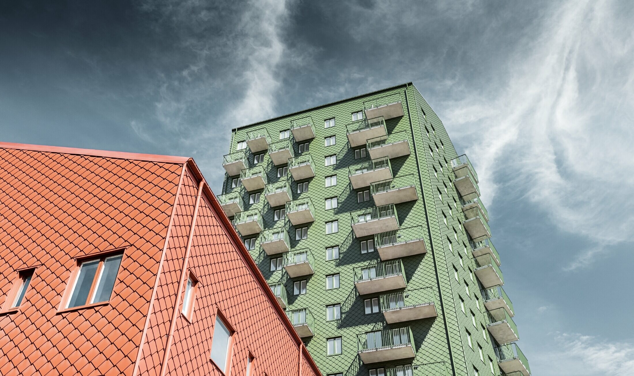 Neboderi s balkonima s fasadom oblikovanom PREFA zidnim rombom 29 × 29 u maslinasto zelenoj i ciglasto crvenoj boji