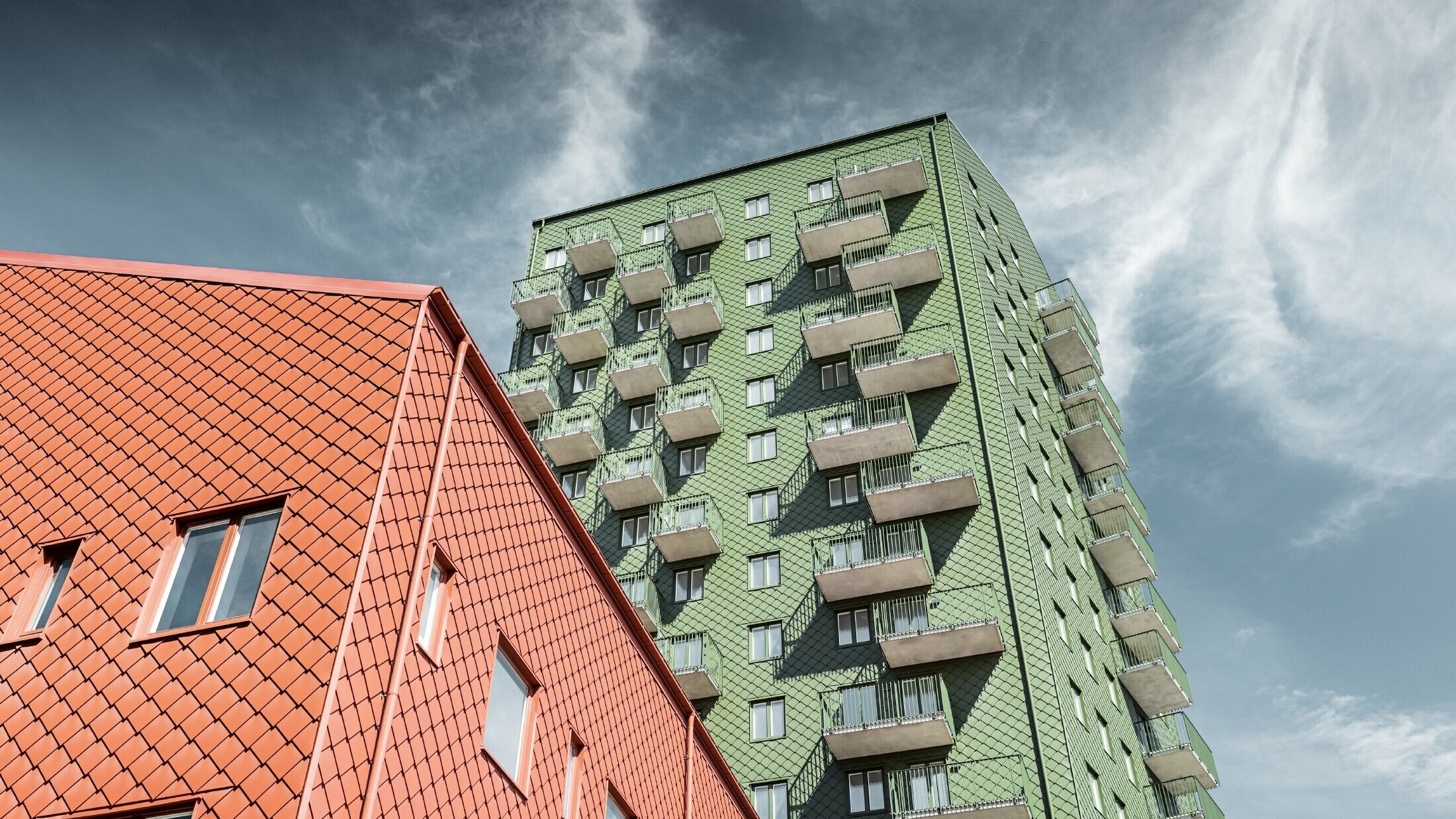 Neboderi s balkonima s fasadom oblikovanom PREFA zidnim rombom 29 × 29 u maslinasto zelenoj i ciglasto crvenoj boji