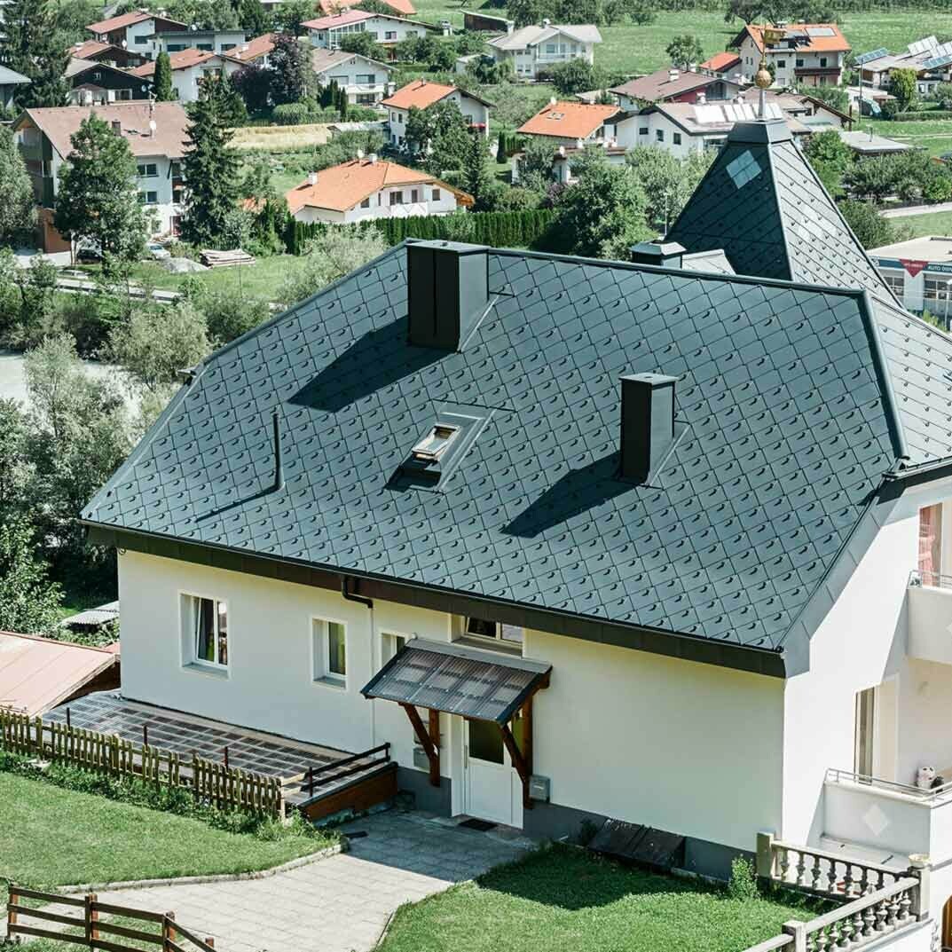 Četverostrešni krov sa zasjekom i tornjićem, pokriven aluminijskim krovnim rombom 44 × 44 u antracit boji.