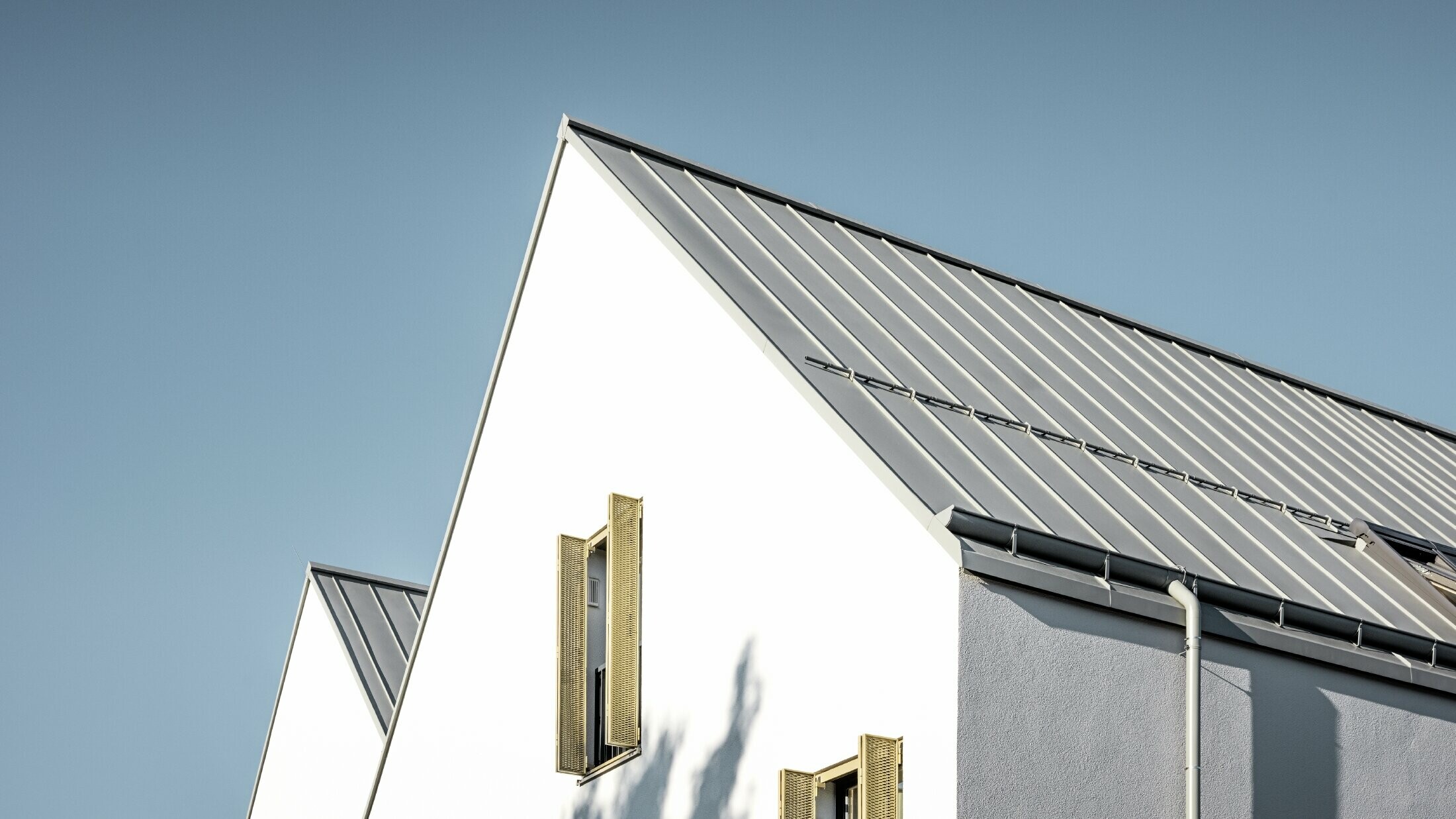 Dvostrešni krov bez strehe, pokriven sustavom PREFALZ u P.10 cink sivoj boji s PREFA ležećim žlijebom
