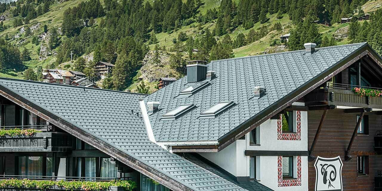 Hotel Alpenhof u Zermattu s Matterhornom u pozadini, tamnom drvenom fasadom i PREFA aluminijskim krovom u antracit boji