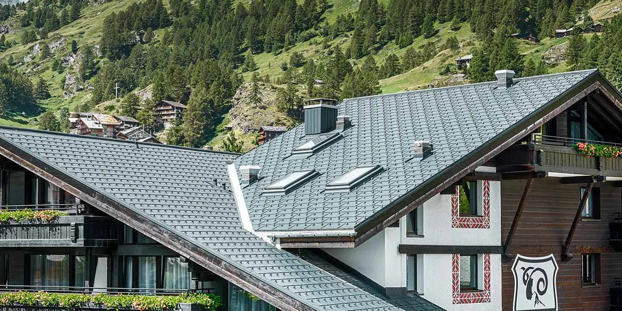 Hotel Alpenhof u Zermattu s Matterhornom u pozadini, tamnom drvenom fasadom i PREFA aluminijskim krovom u antracit boji
