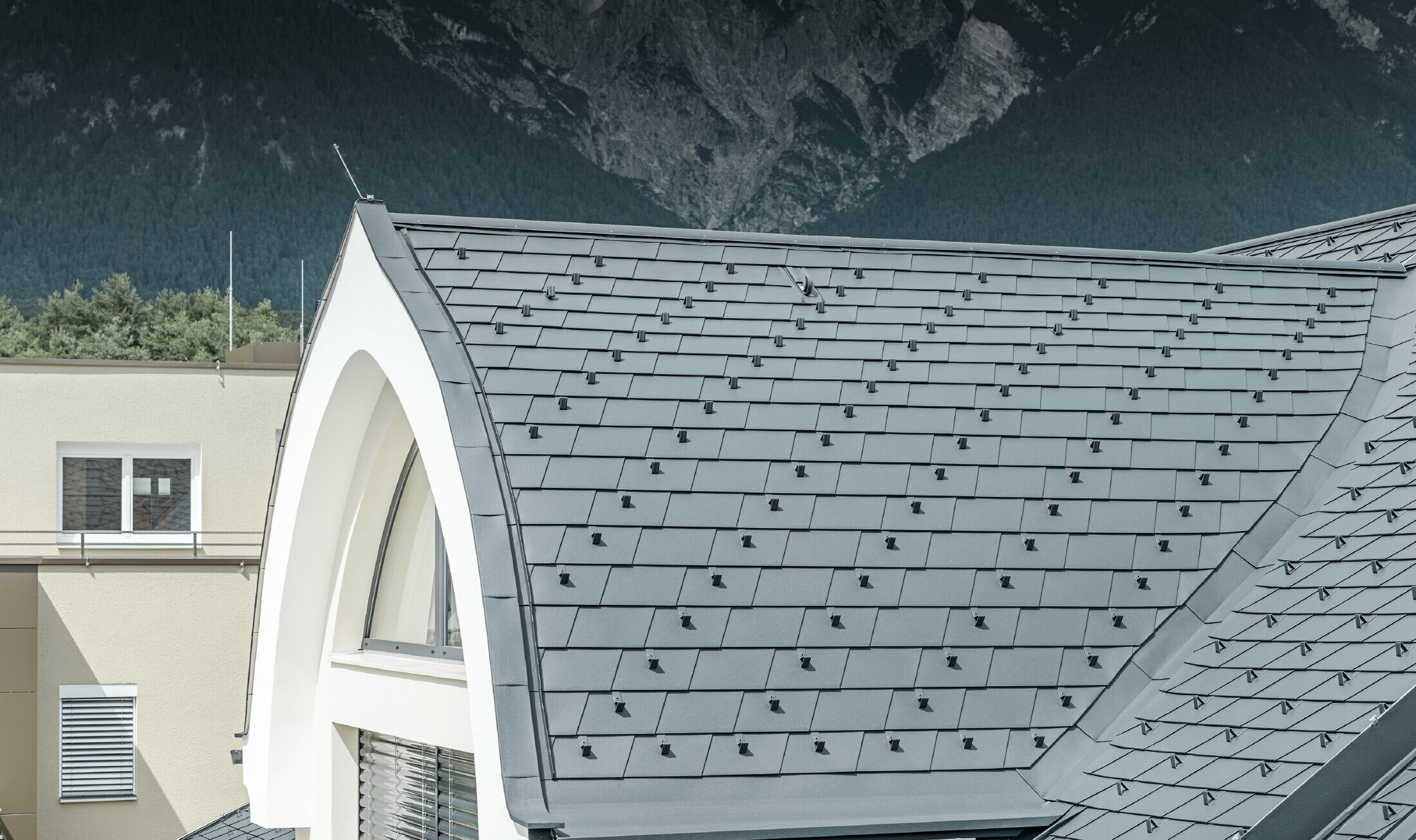 Snimka detalja šiljasto bačvaste krovne kućice, pokrivene PREFA krovnom šindrom u antracit boji; Krovna kućica ovdje je izvedena kao šiljasto bačvasti krov.