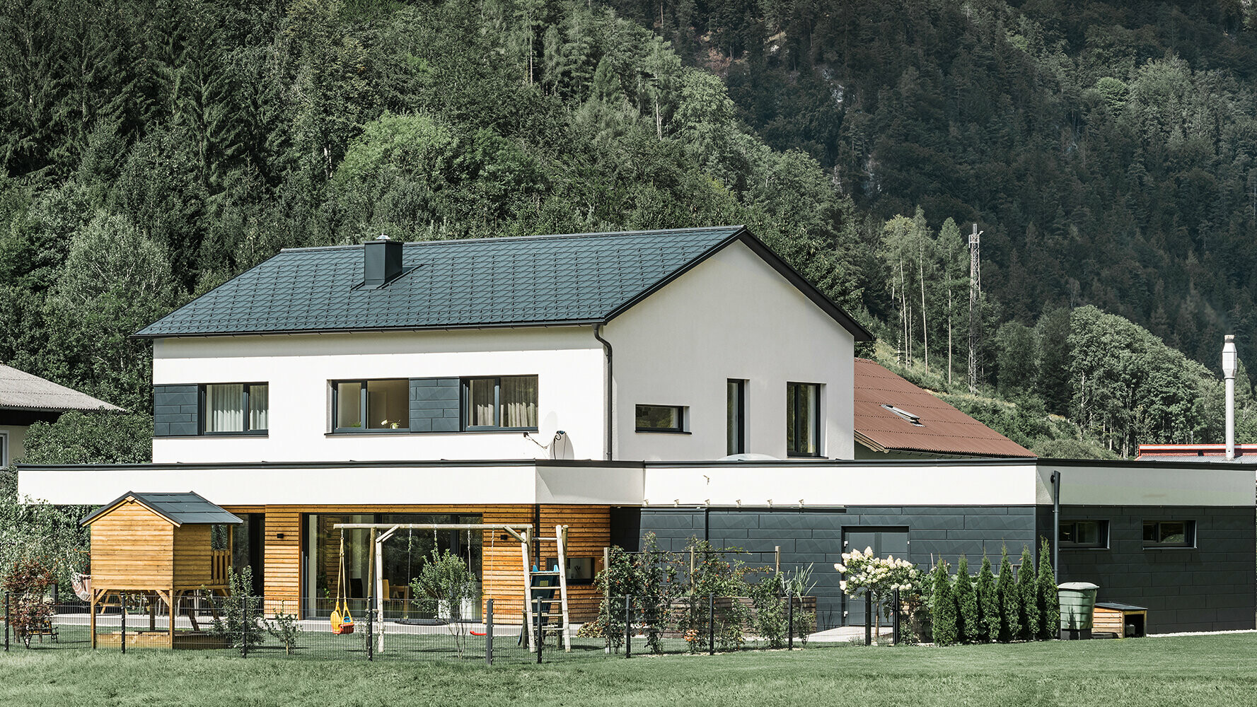 Novo izgrađena obiteljska kuća s fasadom od ariševine u kombinaciji s PREFA panelom Siding.X u antracit boji.