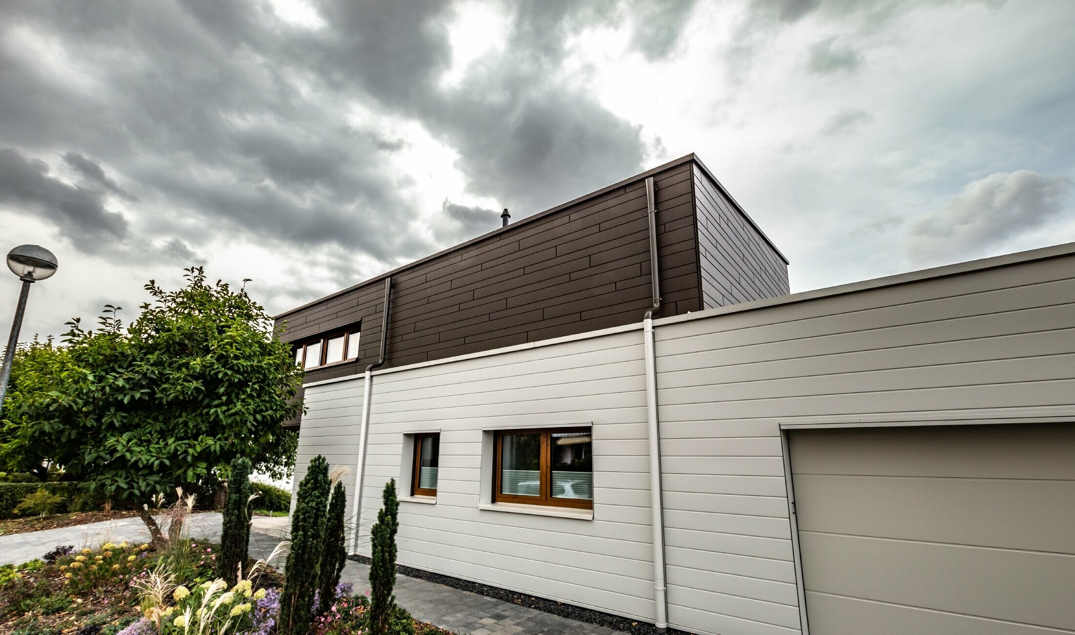 Fasadna obloga garaže s PREFA kazetama Siding horizontalnim u bijeloj boji, s bočnim uljevom.