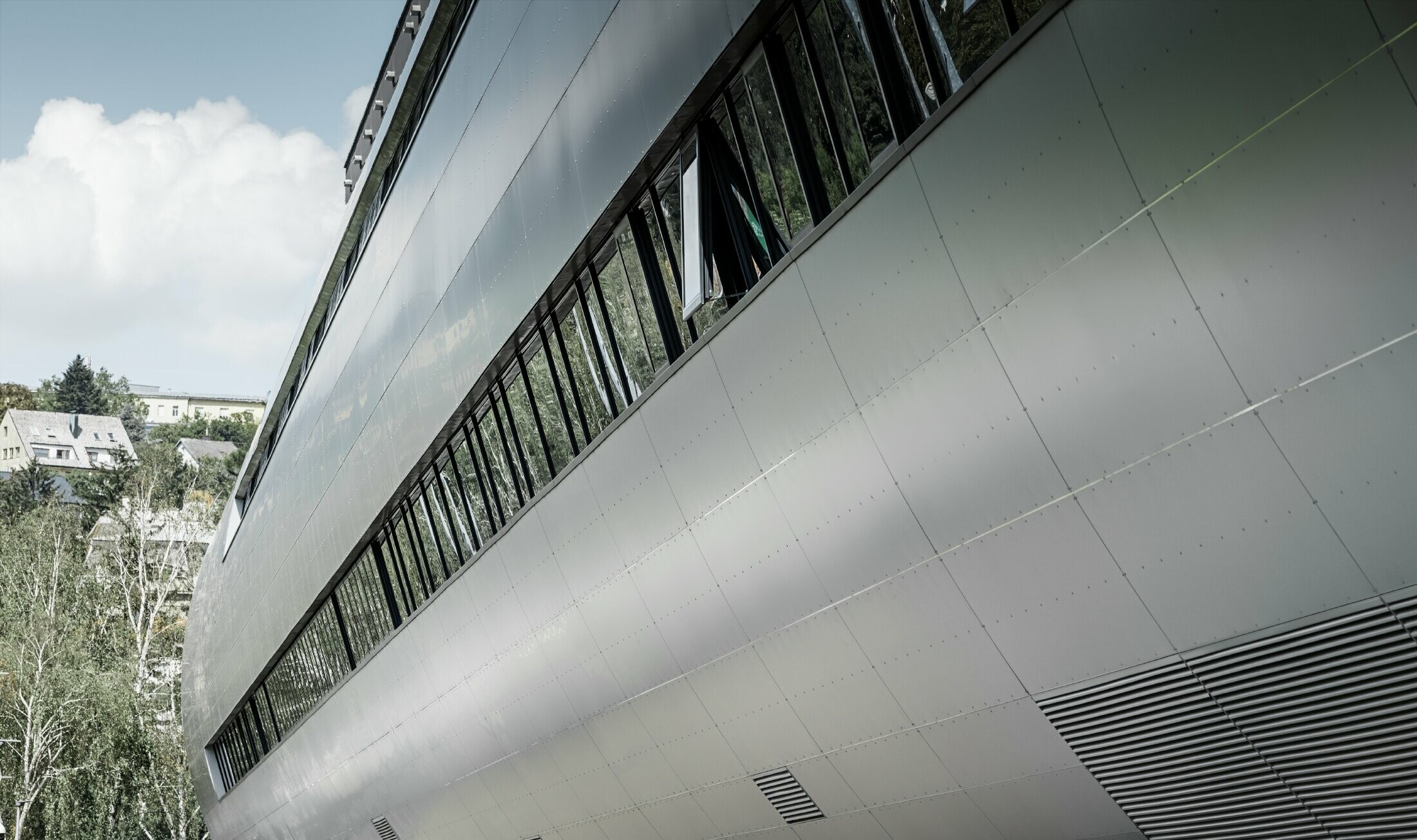 Pogled sa strane na cijev na stadionu Allianz u Beču za SK Rapid; Cijev je obložena aluminijskom kompozitnom pločom u srebrnoj metalik.