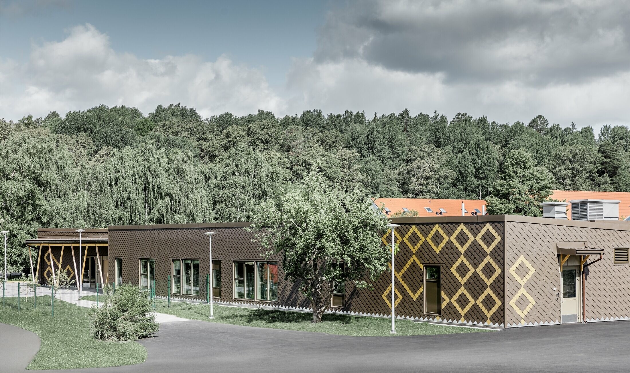 Fasadna obloga predškolske ustanove u Stockholmu izvedena je s PREFA zidnim rombom 20 u smeđoj i mayagold zlatnoj boji.