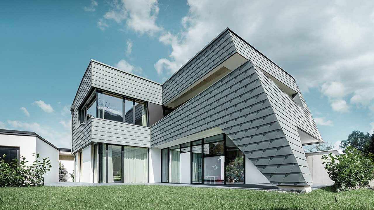 Moderna obiteljska kuća s ovješenom aluminijskom fasadom tvrtke PREFA. Za oblogu je korištena zidna šindra u kameno sivoj.