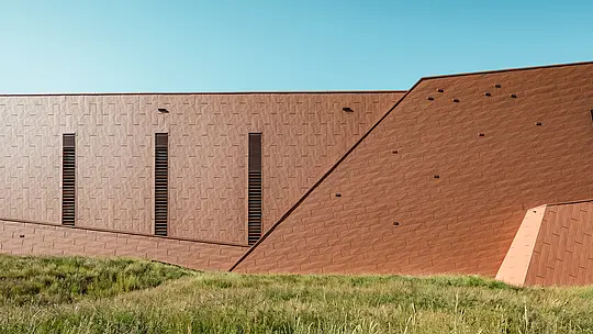 Crpna stanica za pitku vodu u Lottumu (Nizozemska) kao skulpturalni volumen zgrade skladno se uklapa u prirodno okruženje. Upečatljiva PREFA Siding.X aluminijska fasada u toplom izgledu hrđe stvara zanimljiv kontrast zelenoj livadi i brežuljcima te očarava svojom fino strukturiranom, živopisnom površinom. Vitki, vertikalni otvori postavljaju precizne naglaske. Dugotrajni, lagani i potpuno reciklabilni PREFA aluminijski paneli odlikuju se visokom otpornošću na vremenske uvjete, postojanošću boje te održivim fasadnim omotačem koji zahtijeva minimalno održavanje. Time je crpna stanica za pitku vodu arhitektonski atraktivan primjer u području infrastrukturne gradnje.