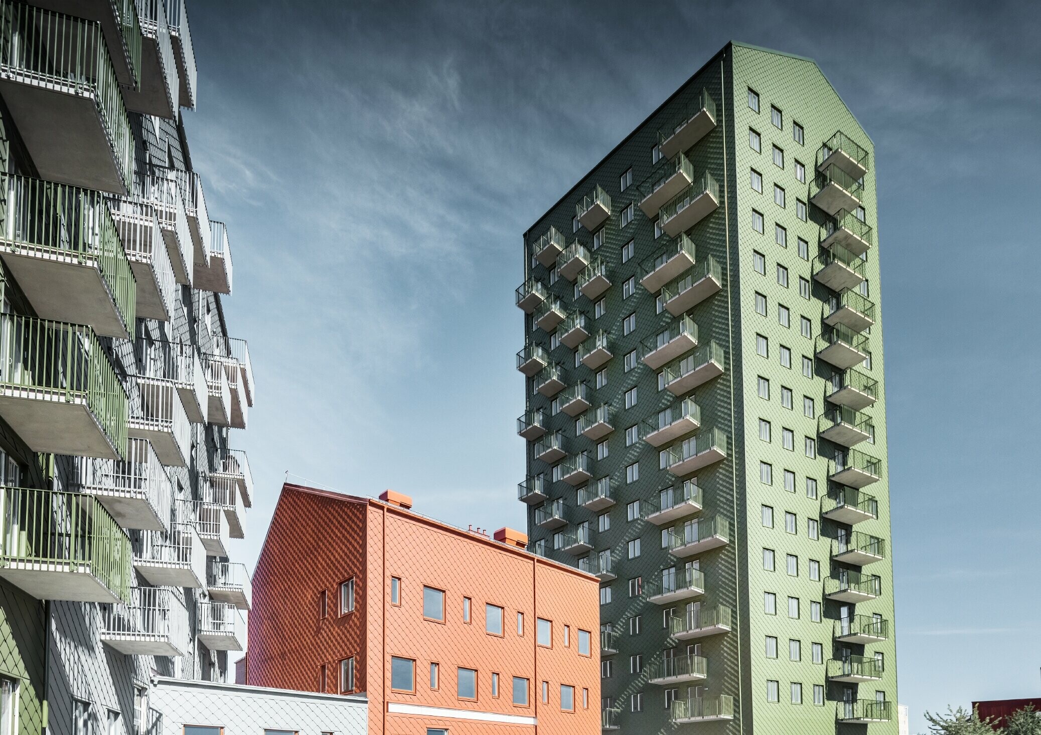 Više stambenih zgrada obloženih PREFA zidnim rombom 29 × 29 u bojama maslinasto zelena, ciglasto crvena i svijetlo siva u Göteborgu, Švedska.