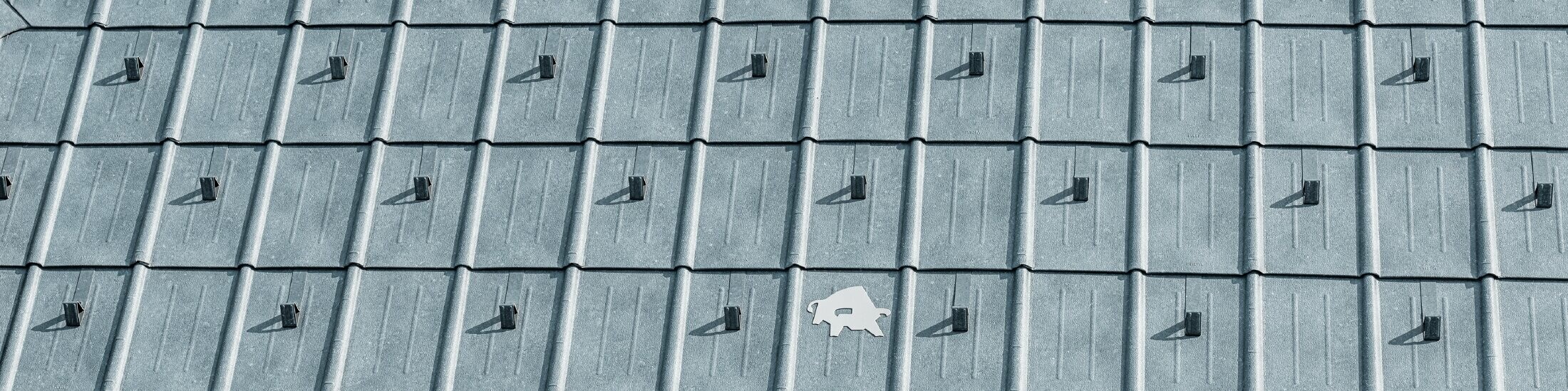 PREFA krovna ploča položena s PREFA logotipom bika u P. 10 Kameno siva; Krovna površina s PREFA limenim krovom