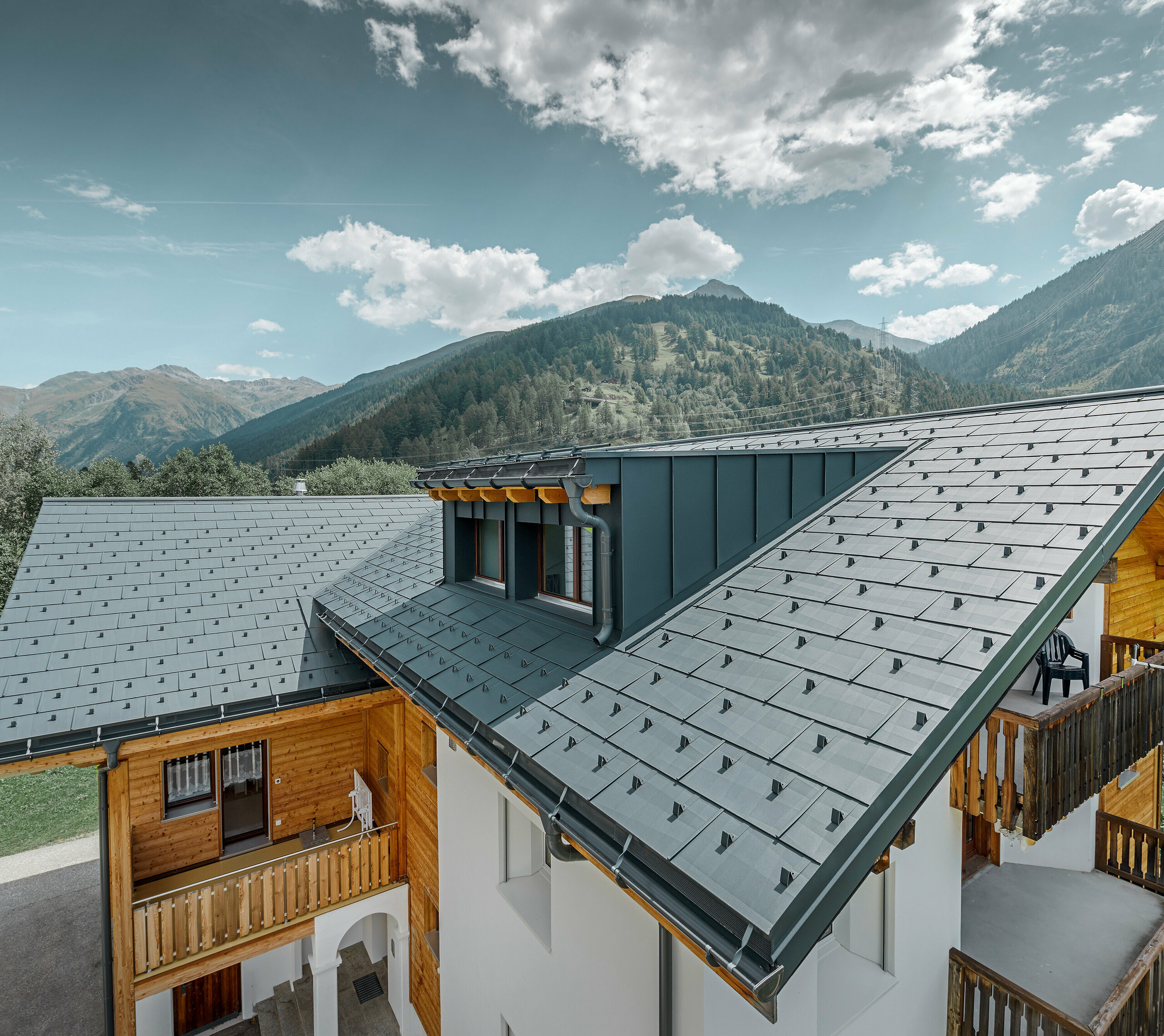 Novo sanirana stambena kuća s dvostrešnim krovom i krovnom kućicom; Sanacija krova provedena je PREFA krovnim panelom FX.12 u antracit boji.