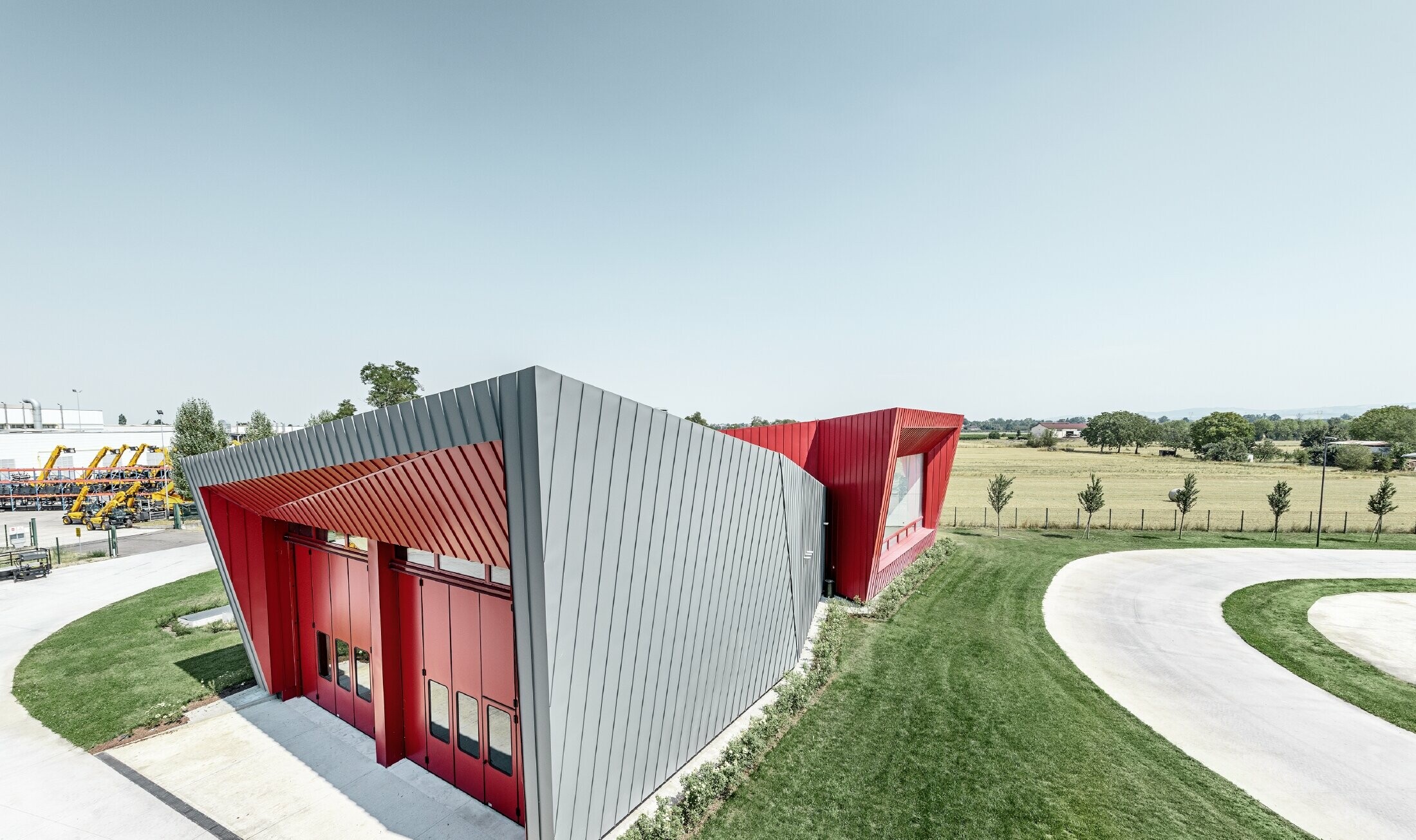 Moderni obrazovni centar s tribinama firme Dieci u Montecchio Emilia, Italija, s aluminijskom fasadom iz Prefalza u svijetlosivoj i Falzonala u karmin crvenoj boji