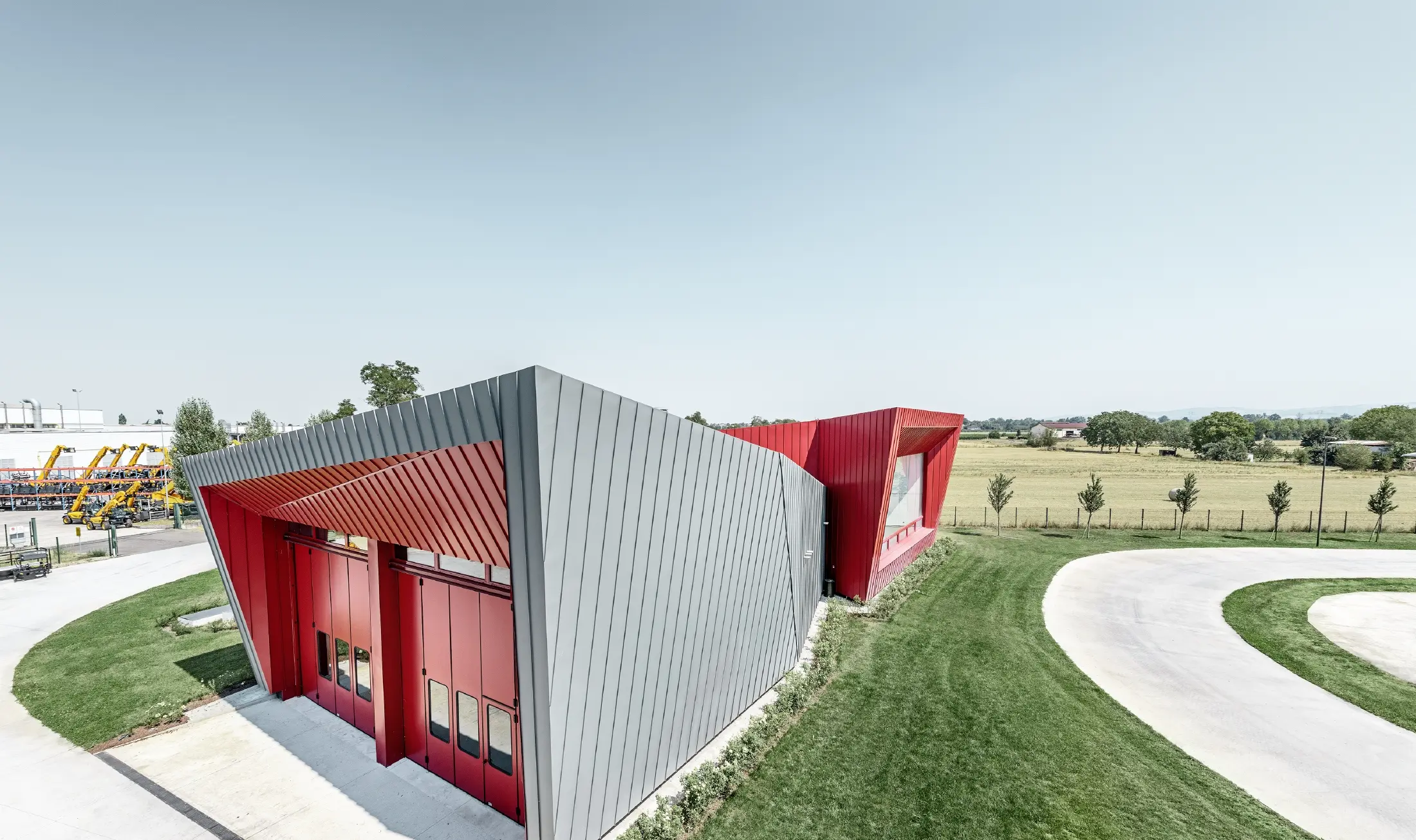 Moderni obrazovni centar s tribinama firme Dieci u Montecchio Emilia, Italija, s aluminijskom fasadom iz Prefalza u svijetlosivoj i Falzonala u karmin crvenoj boji
