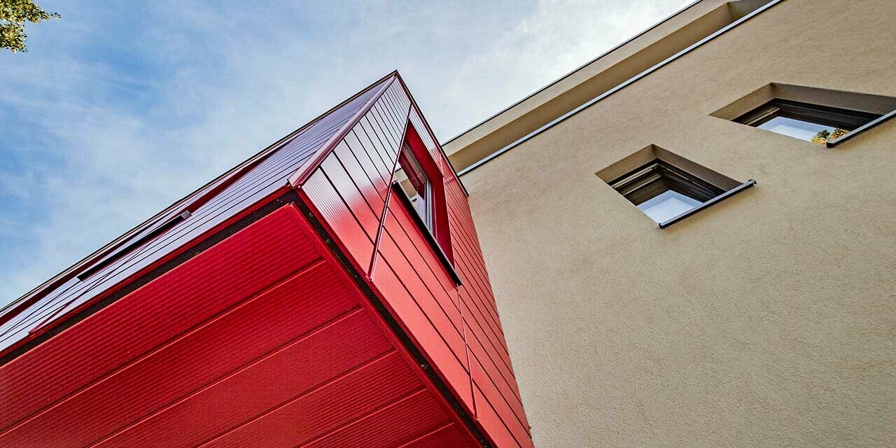 Doksat s liniranim PREFA kazetama Siding u rubin crvenoj na modernoj obiteljskoj kući u Wernigerodeu, ovdje je fotografirano podsvođe izbočene dogradnje.