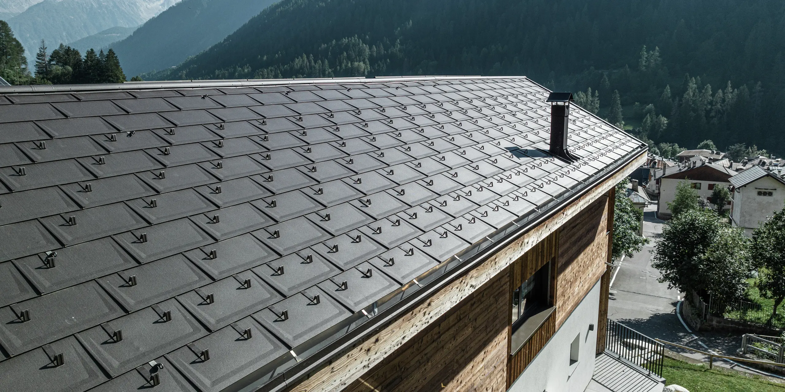 Nahaufnahme von PREFA Dachplatten R.16 in P.10 Braun verleihen dieser Berghütte in Cogolo, Val di Sol, eine stilvolle Optik und bieten auch maximalen Schutz vor extremen Witterungsbedingungen. Die langlebige Aluminiumeindeckung mit integrierten Schneestoppern sorgt für Sicherheit und Stabilität in alpinen Höhen. Ein wartungsarmes und ästhetisches Dach für Generationen.